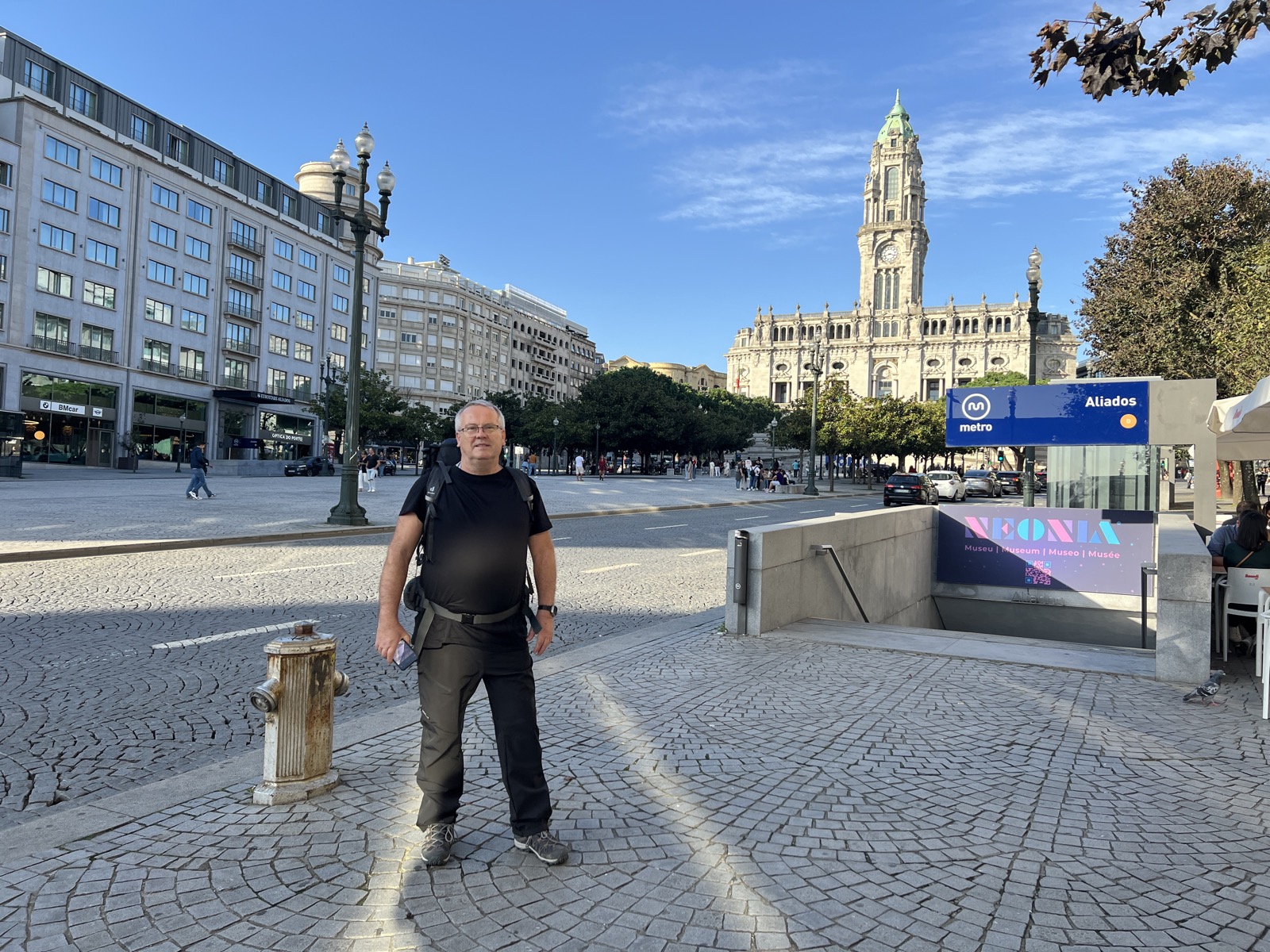 Poutník s batohem na startu Camino Portugués v Portu před radnicí na náměstí Aliados