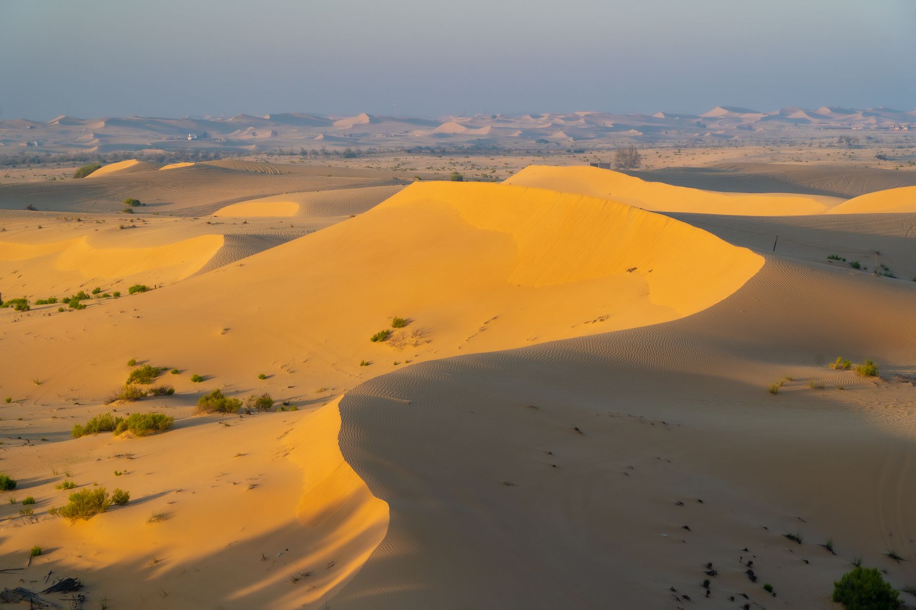 Písečné duny pouště poblíž oblasti Liwa v emirátu Abu Dhabí za západu slunce