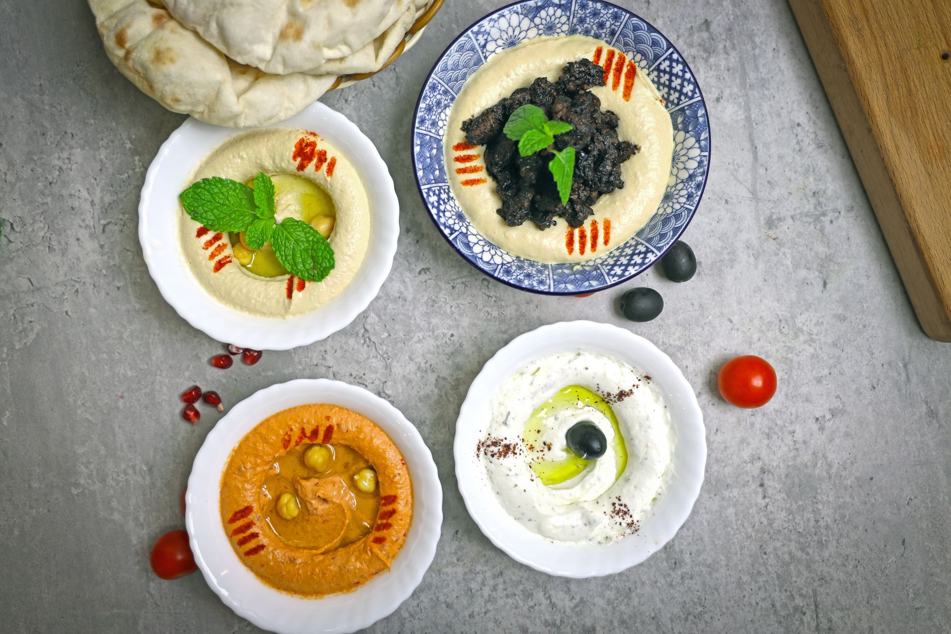 Talíř tradiční arabské mezze s hummusem, plackami a grilovaným masem v Al Ain