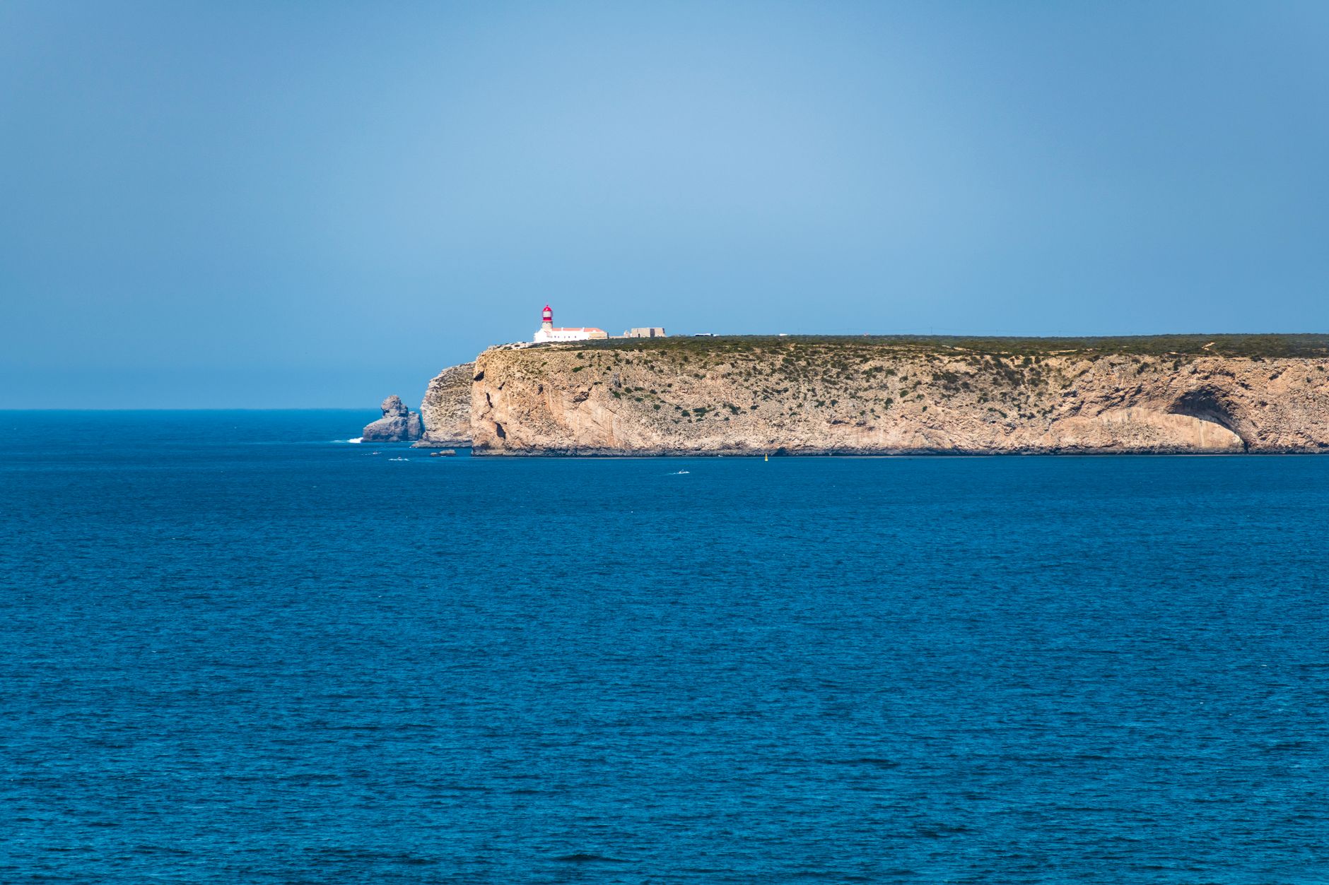 Maják a strmé útesy na mysu Cabo de São Vicente na západním cípu Algarve při západu slunce