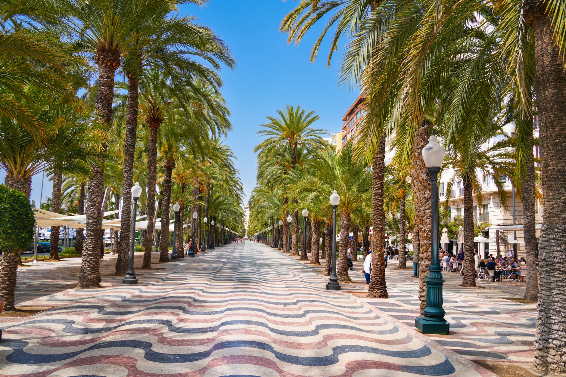 Mramorová promenáda Explanada de España s vlnitým vzorem dlažby a palmami v Alicante