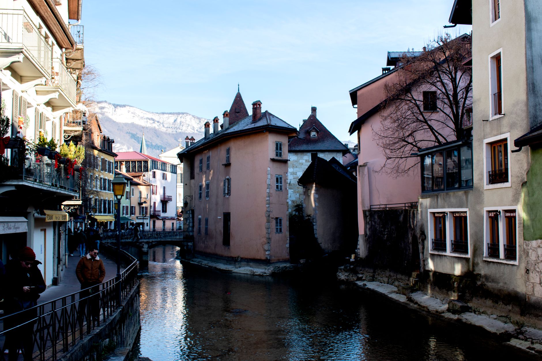 Panorama města Annecy s tyrkysovým jezerem a zasněženými vrcholy Alp v pozadí