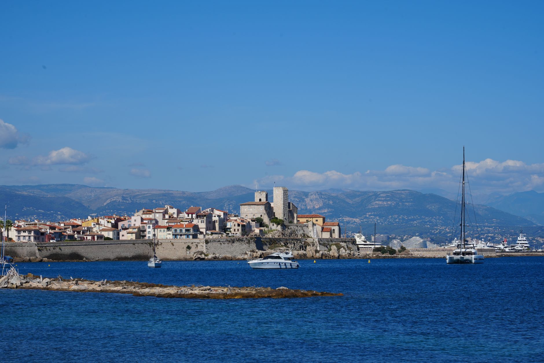 Staré město Antibes s pevností a majákem nad tyrkysovým mořem na Francouzské riviéře