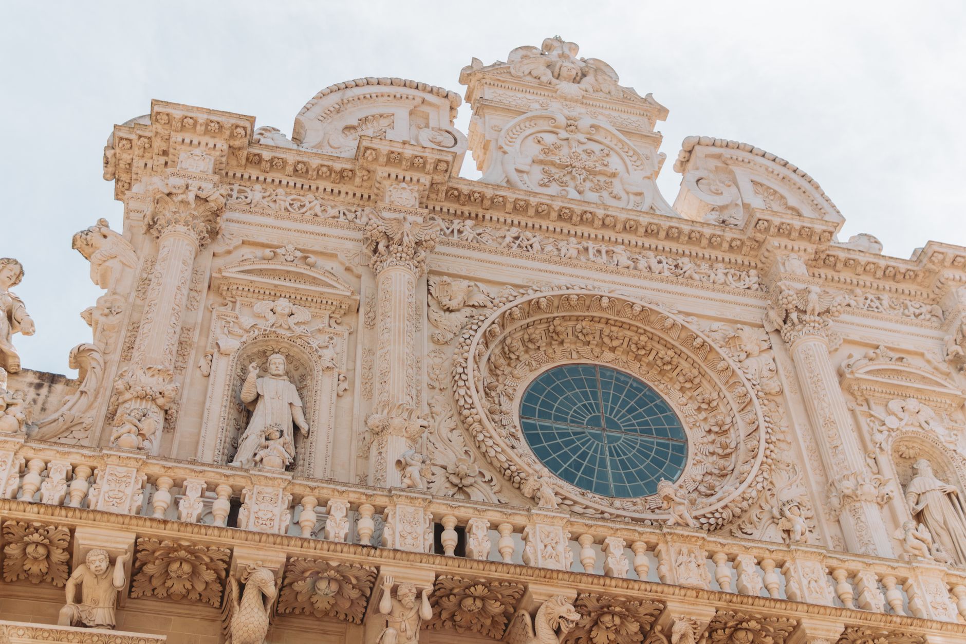 Barokní fasáda baziliky Santa Croce v Lecce s bohatě tesanými kamennými detaily