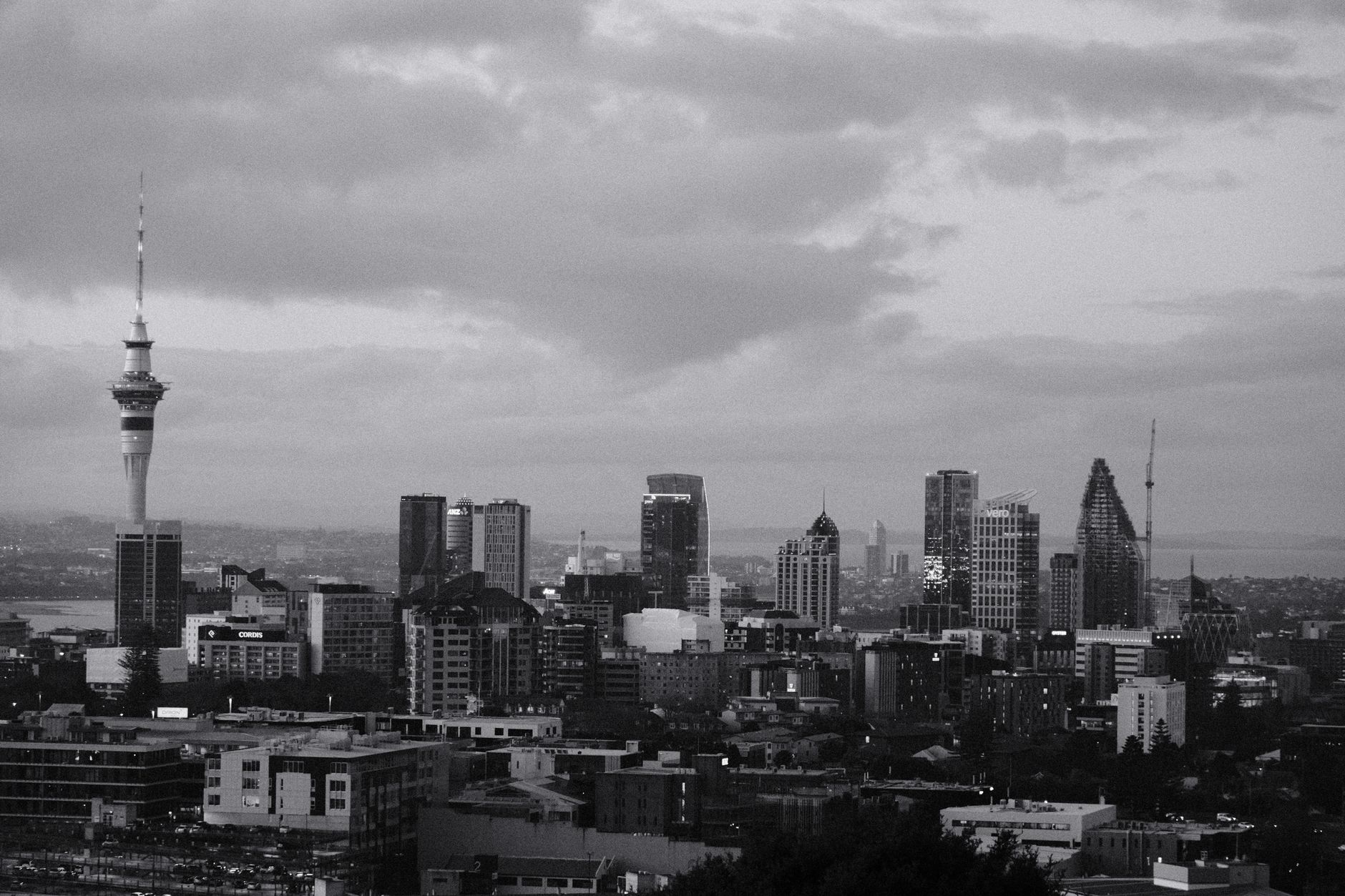 Panorama Aucklandu se Sky Tower a přístavem za soumraku na Novém Zélandu