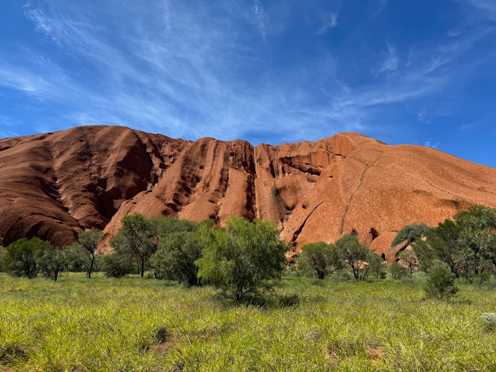 Skalní masiv Uluru v rudé poušti centrální Austrálie za zlatého světla při západu slunce