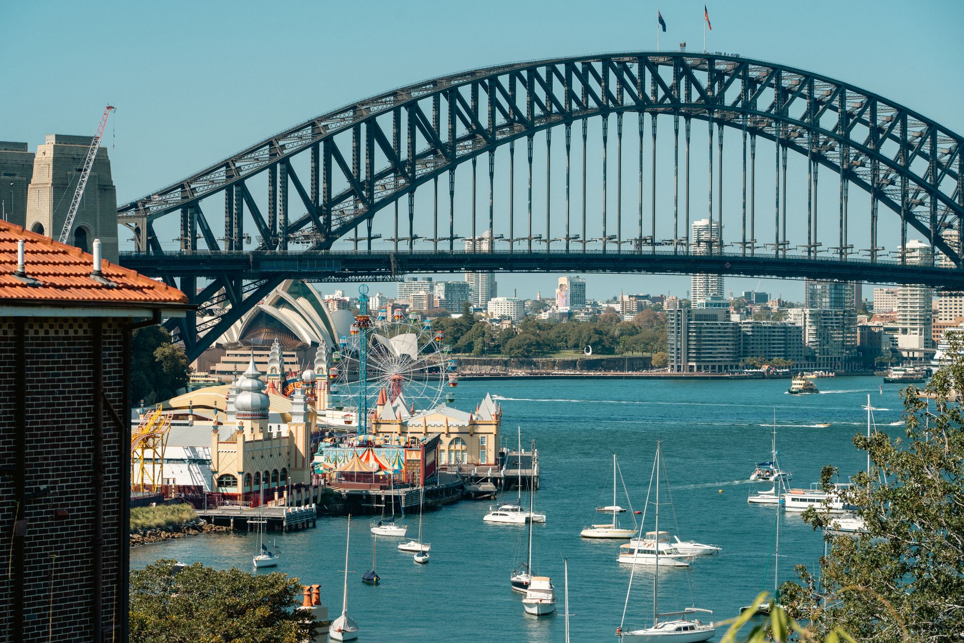 Budova opery v Sydney s mostem Harbour Bridge nad modrým přístavem za jasného dne
