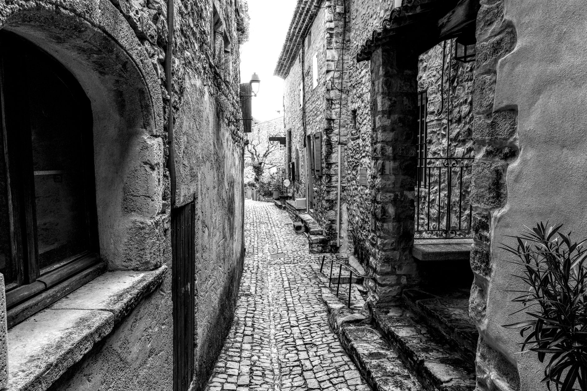 Úzká dlážděná ulička ve starém městě Avignon s kamennými domy