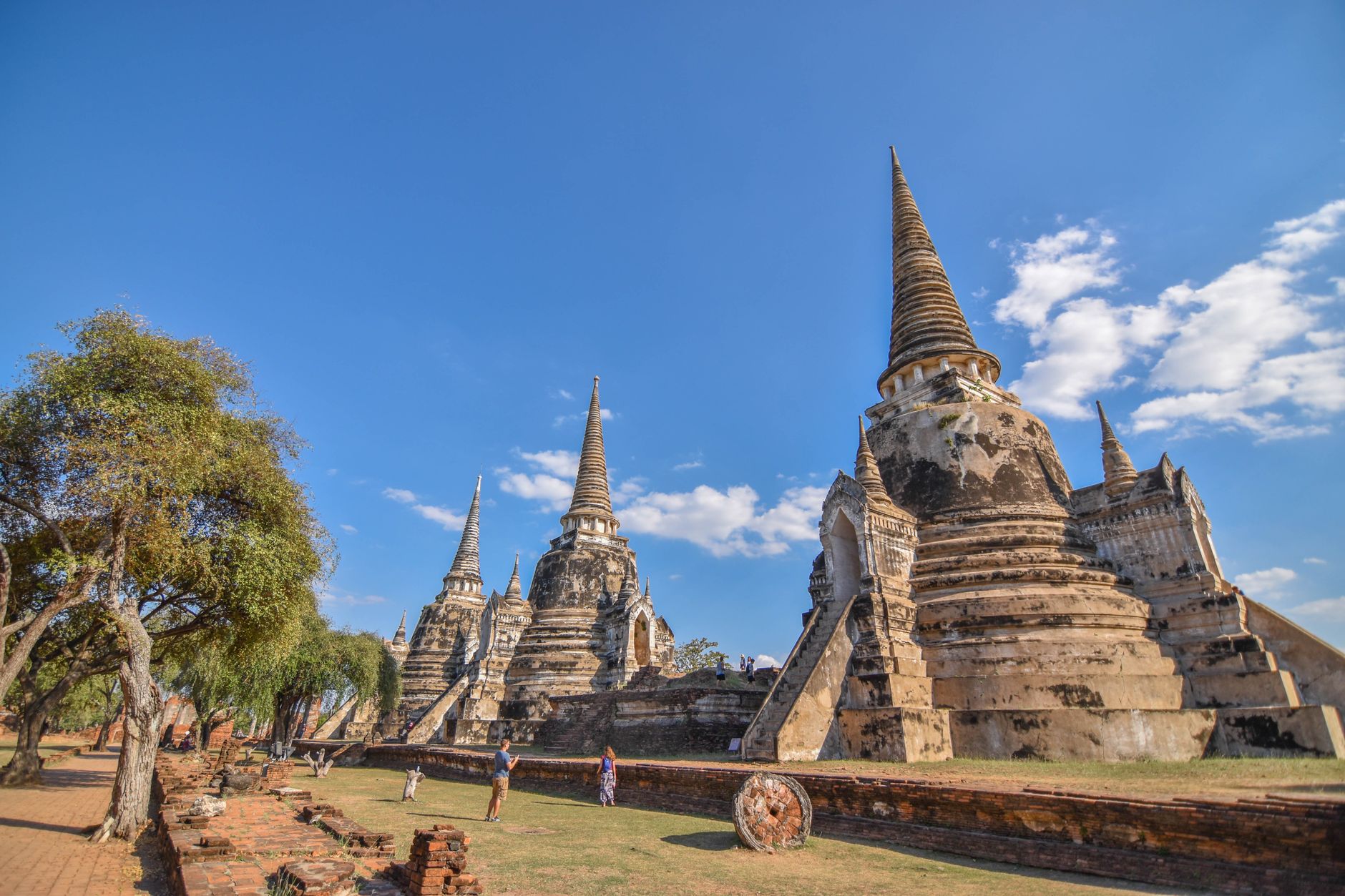 Tři zvonovité věže chedi chrámu Wat Phra Si Sanphet v řadě proti modré obloze