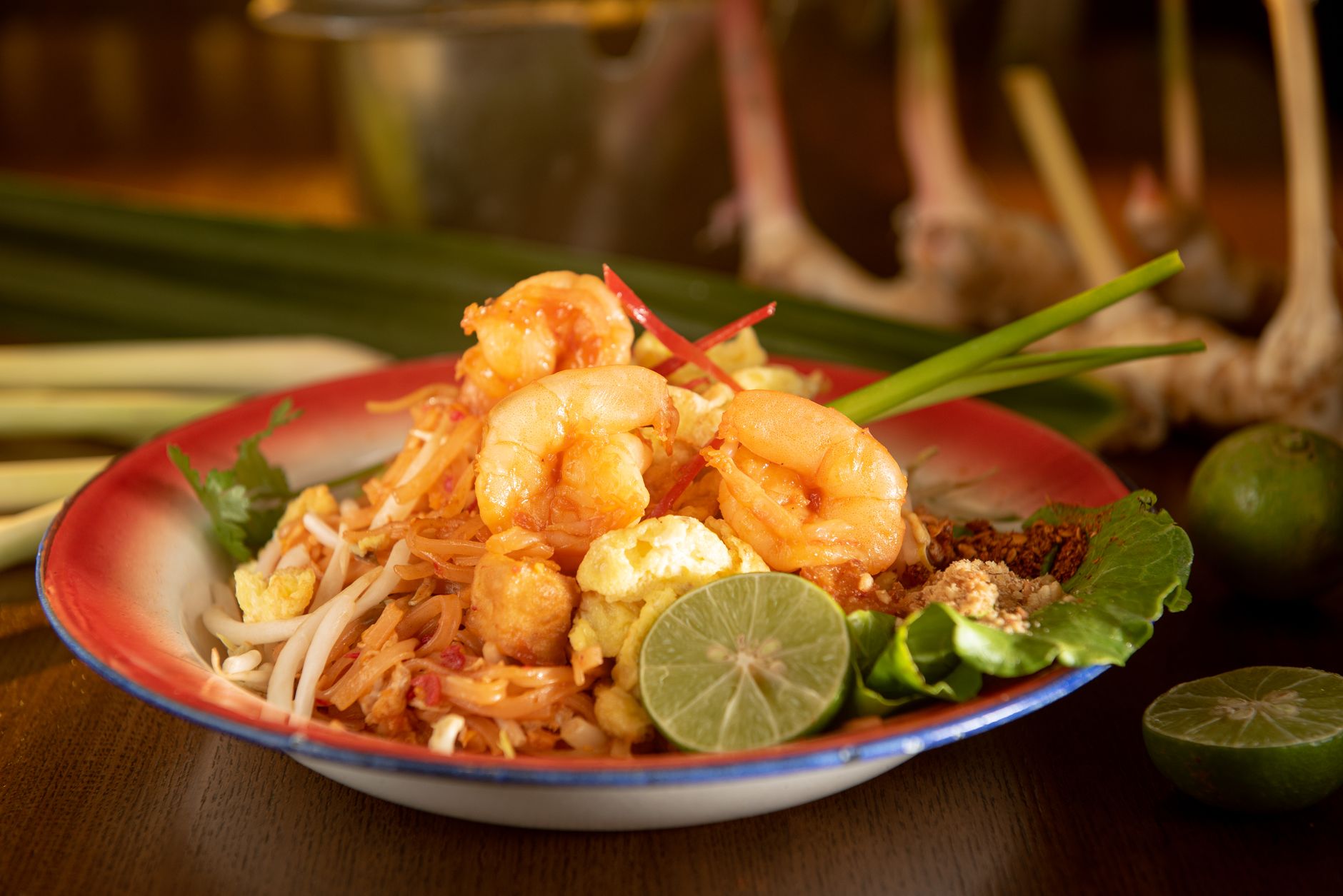 Talíř thajského pad thai s krevetami a limetkou na stánku v Bangkoku