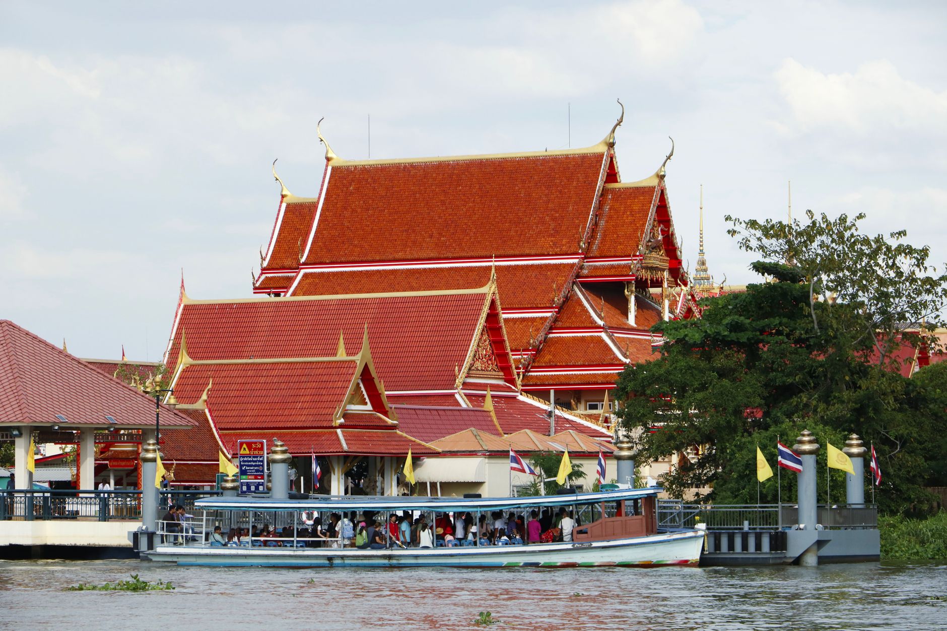 Linkový člun na řece Chao Phraya v Bangkoku s chrámem na břehu