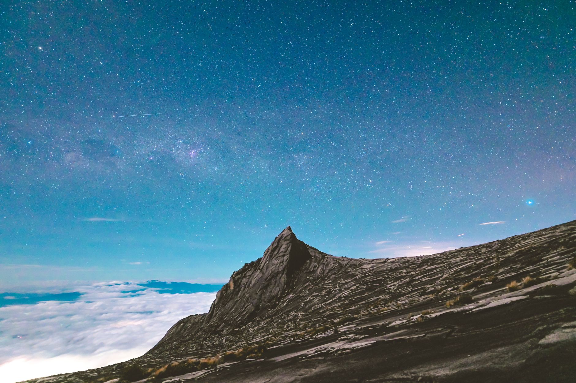 Hora Kinabalu se skalnatým vrcholem vystupujícím nad ranní mlhu na Borneu