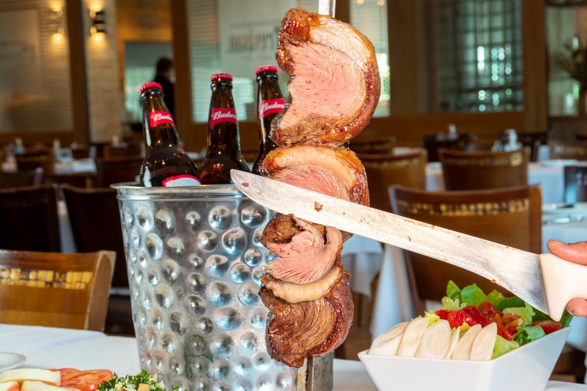 Tradiční brazilské grilované maso churrasco na rožni v restauraci typu churrascaria