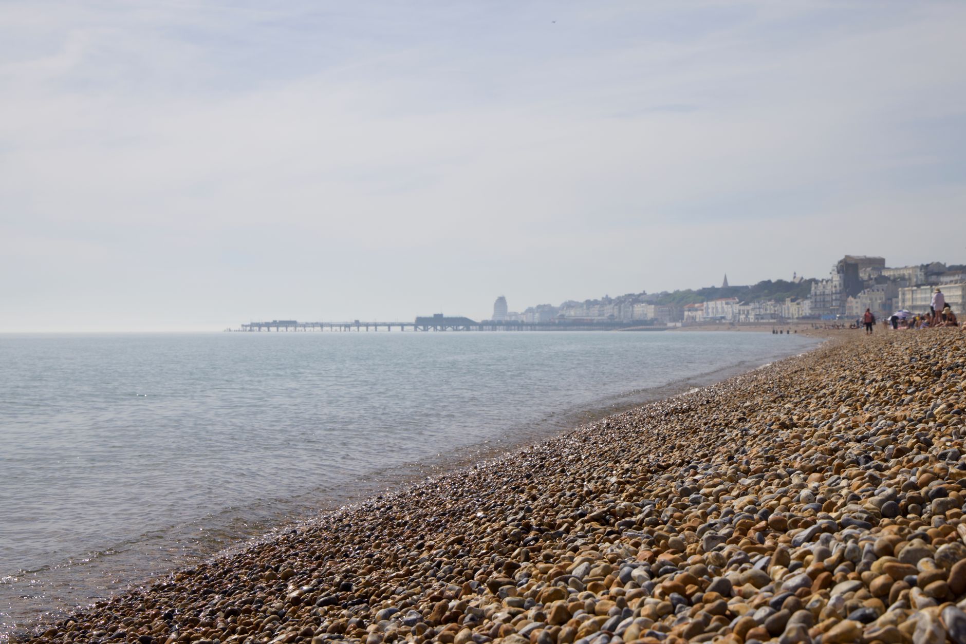 Brighton Palace Pier nad mořem s kolotoči, atrakcemi a oblázkovou pláží pod molem