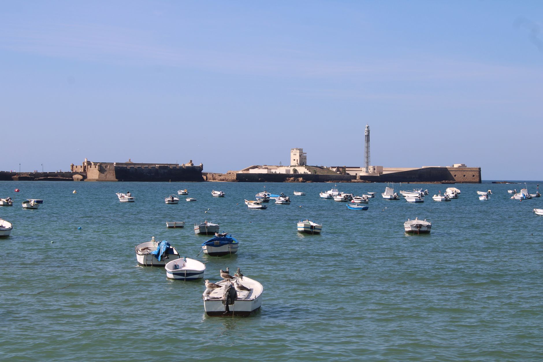 Západ slunce nad Atlantikem a pláží La Caleta mezi pevnostmi v Cádizu