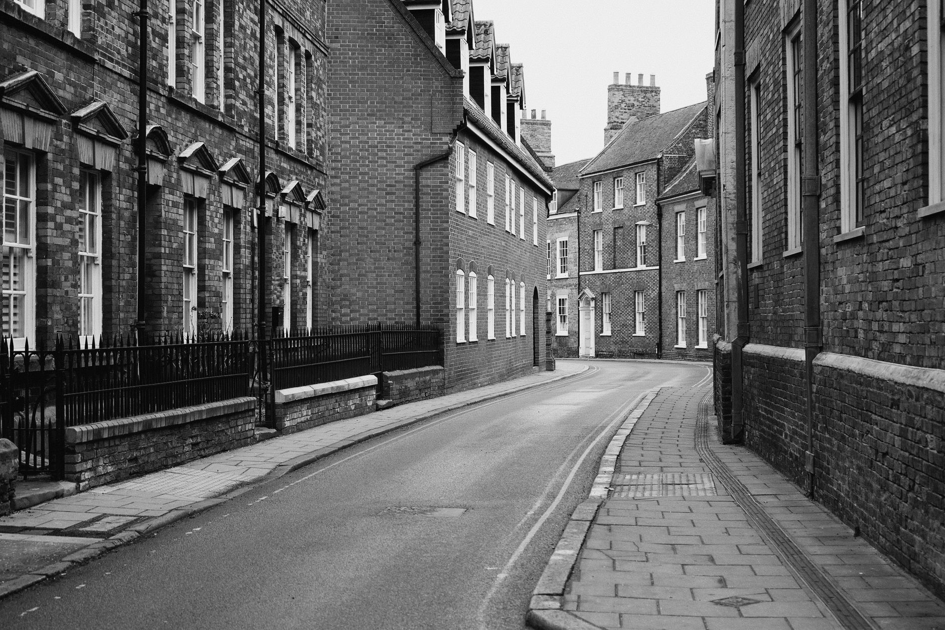 Studenti na kolech v úzké historické uličce v centru Cambridge