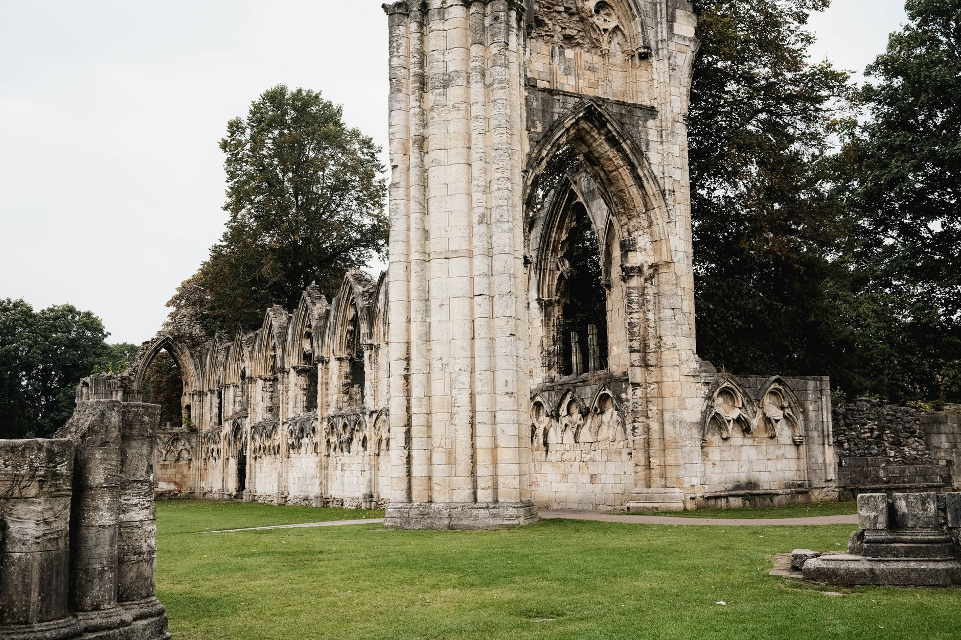 Kamenné ruiny opatství St Augustine's Abbey s travnatými plochami v Canterbury