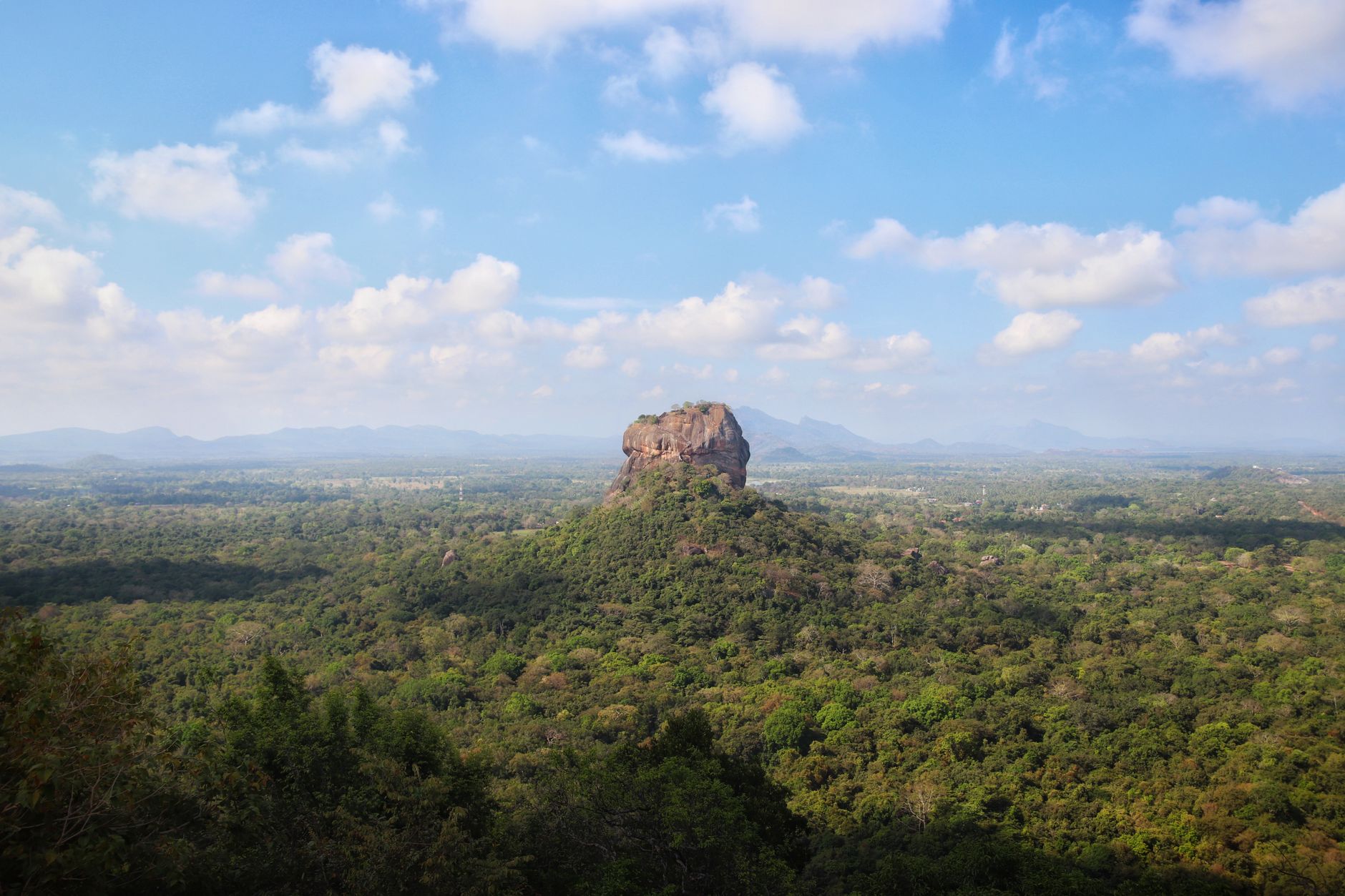 Skála Sigiriya na Srí Lance vystupující nad zelenou džungli za jasného dne