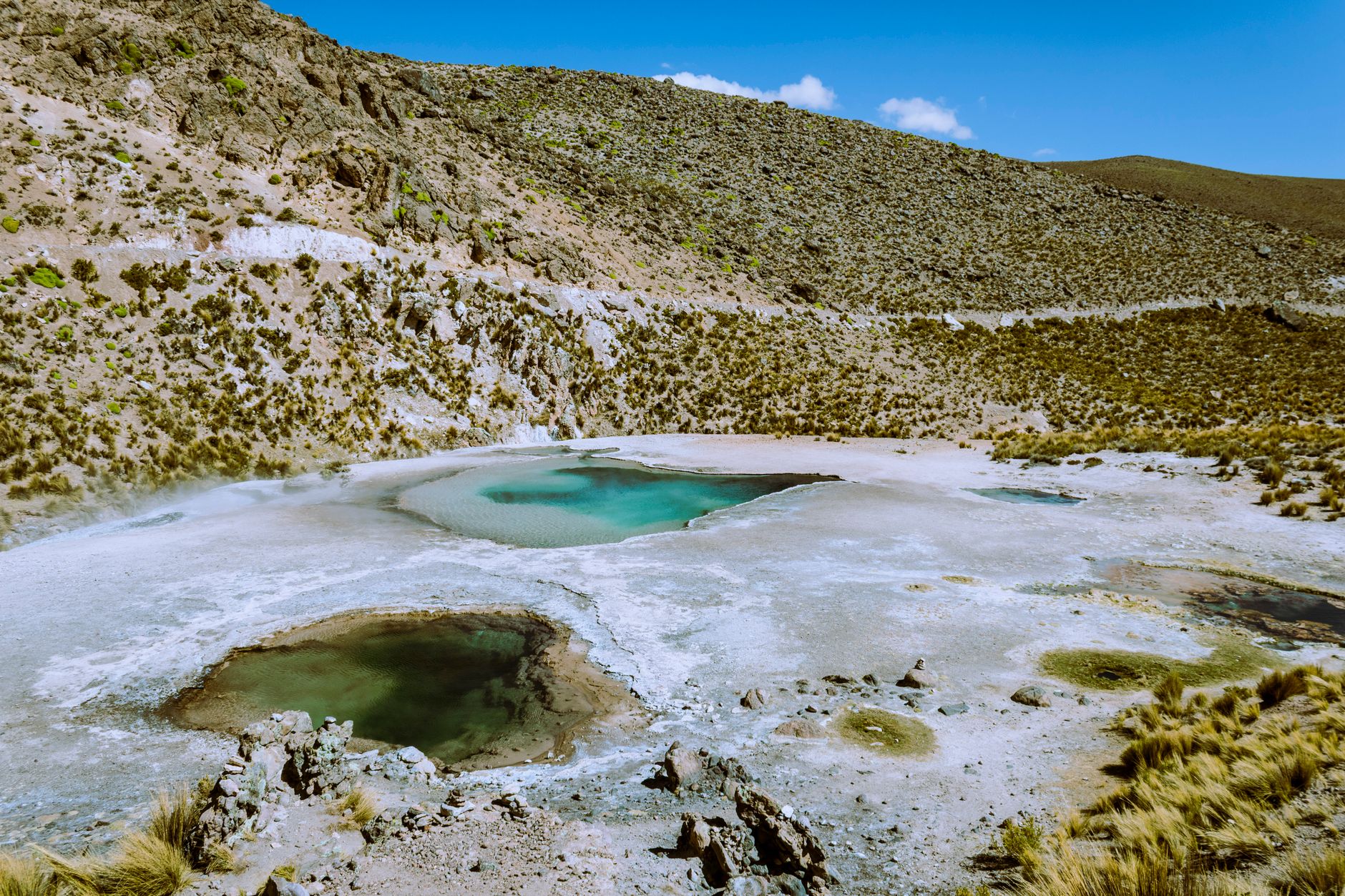 Sloup páry stoupající z gejzírů El Tatio za úsvitu v chilských Andách