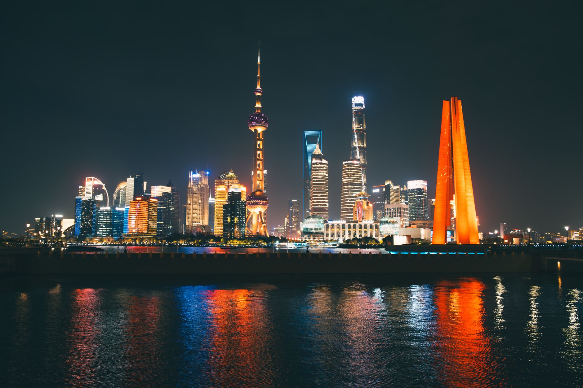 Noční panorama mrakodrapů čtvrti Pudong v Šanghaji odrážející se v řece Huangpu
