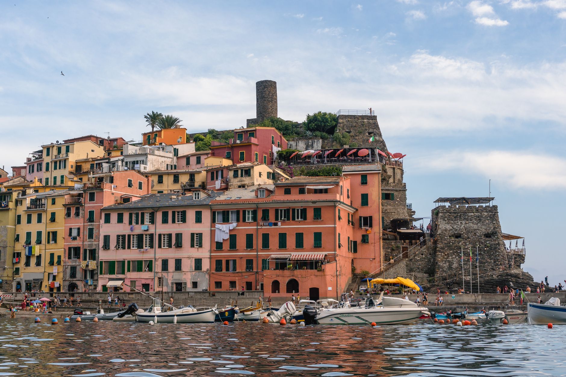 Barevné domy vesnice Riomaggiore stoupající uličkou nad rybářským přístavem v Cinque Terre