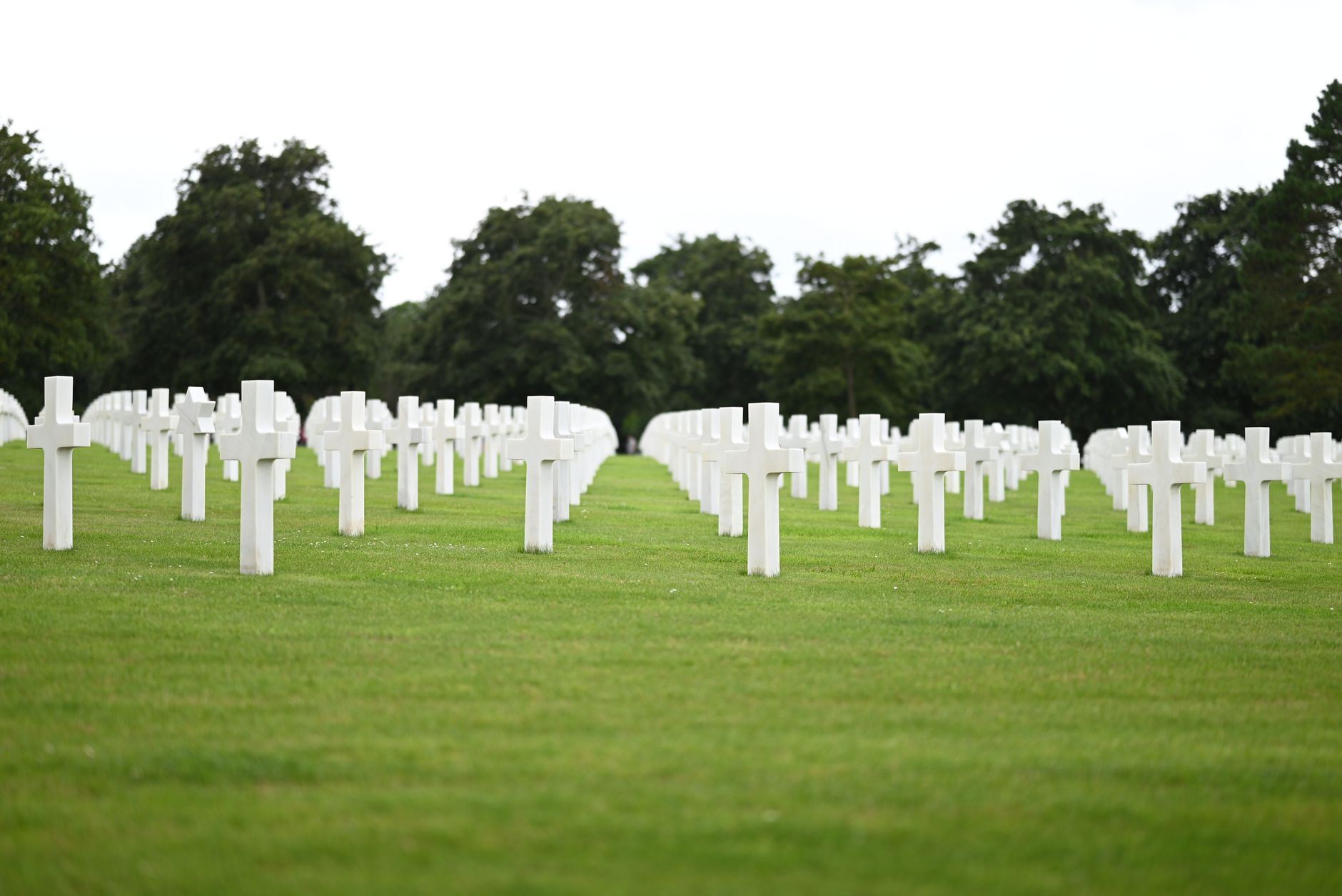 Řady bílých mramorových křížů na Normandském americkém hřbitově nad Omaha Beach