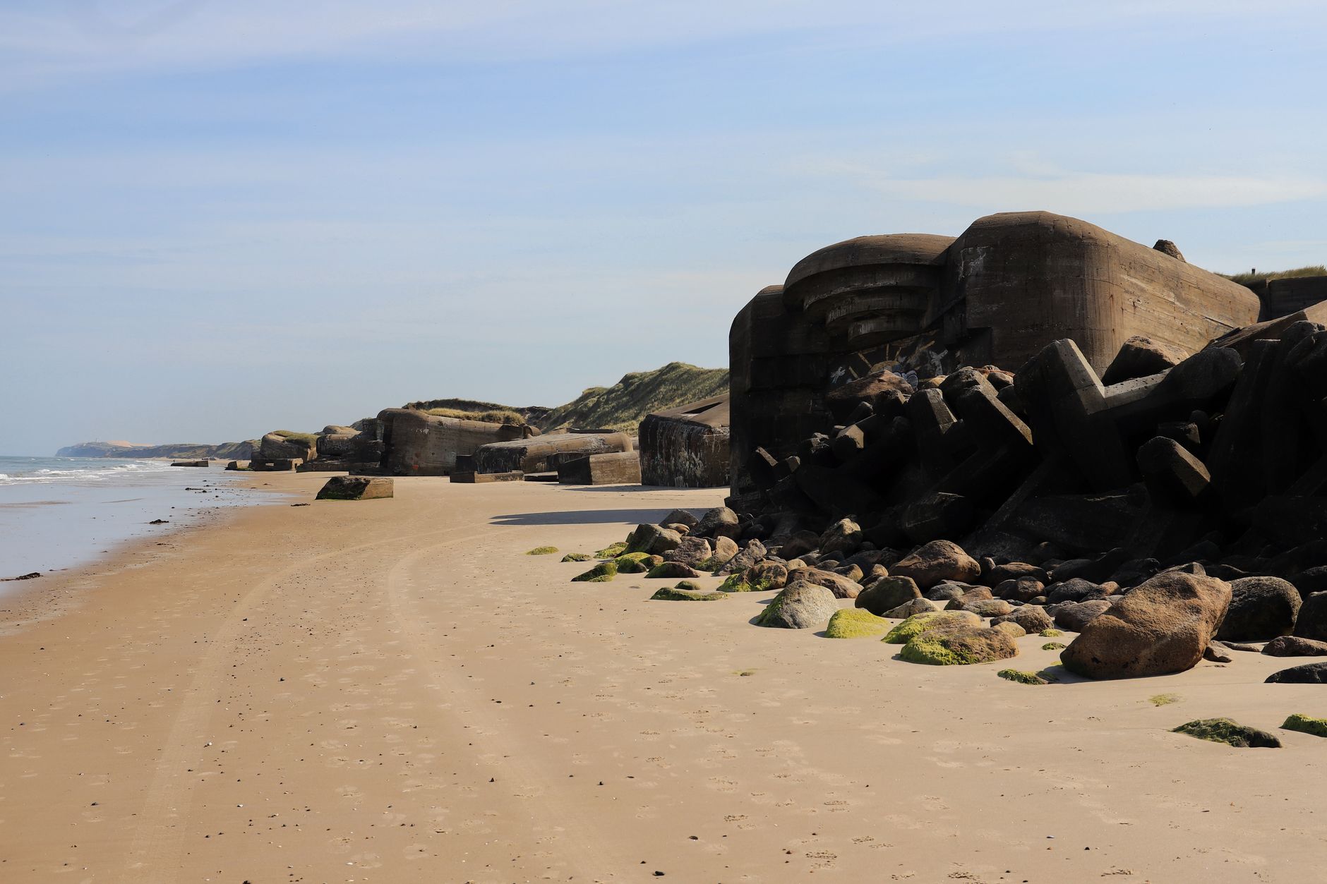 Betonový německý bunkr a kráter po bombardování na ostrohu Pointe du Hoc v Normandii
