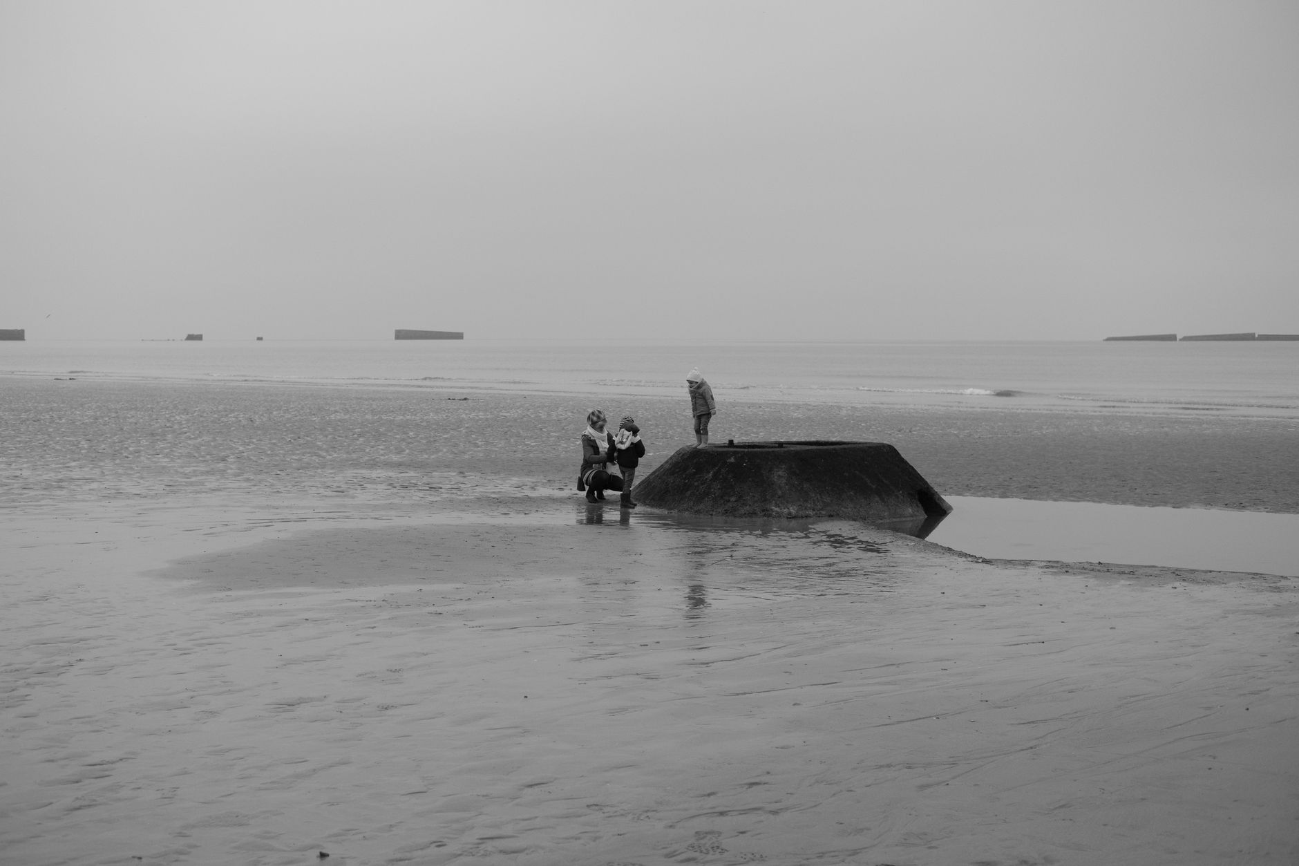 Rezavé pozůstatky umělého přístavu Mulberry v moři u Arromanches v Normandii za odlivu