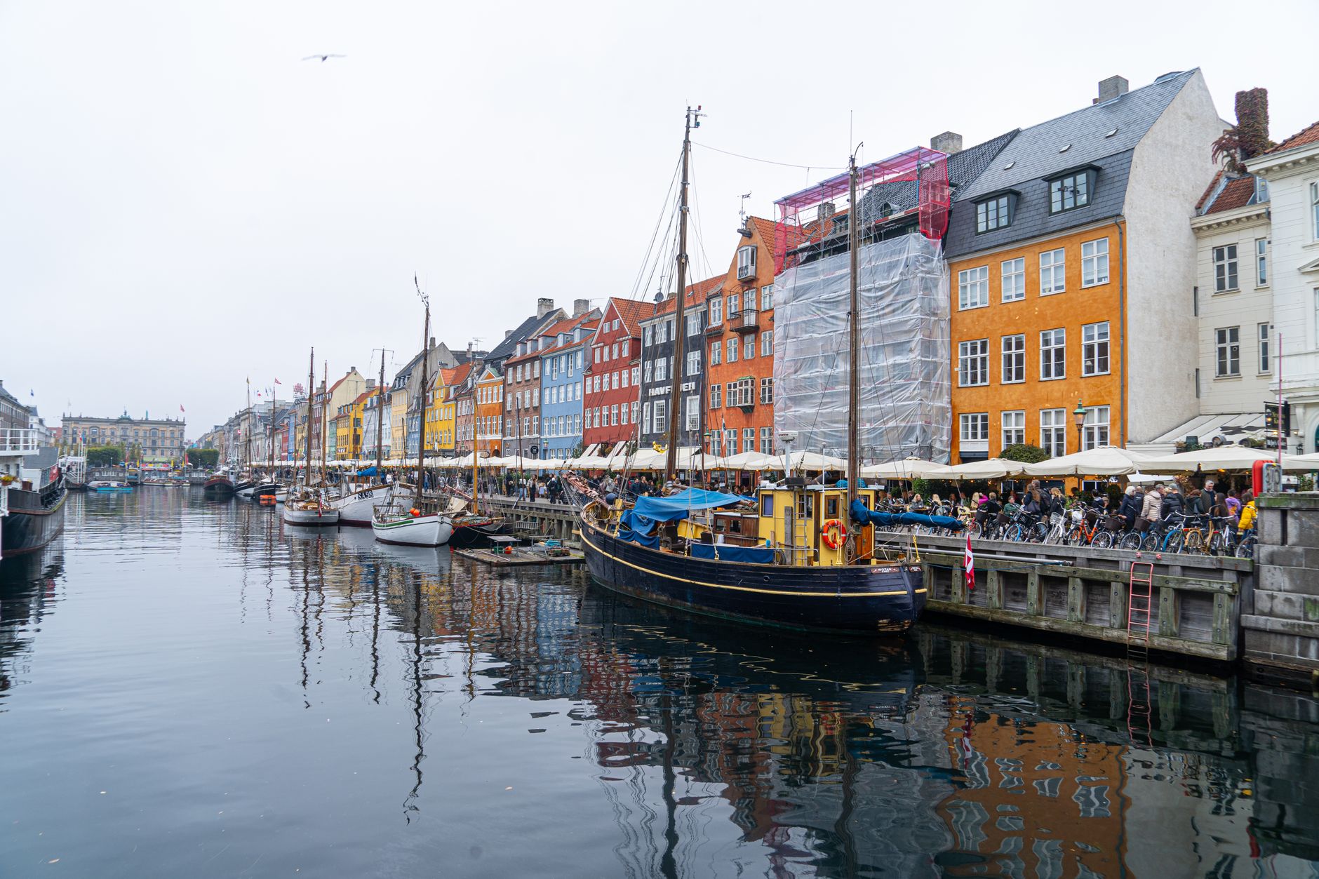 Barevné domy a historické lodě na nábřeží Nyhavn v Kodani za slunečného dne