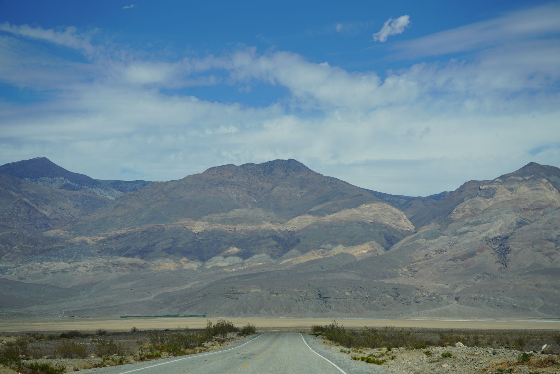 Prázdná rovná silnice mizící v pouštní krajině národního parku Death Valley