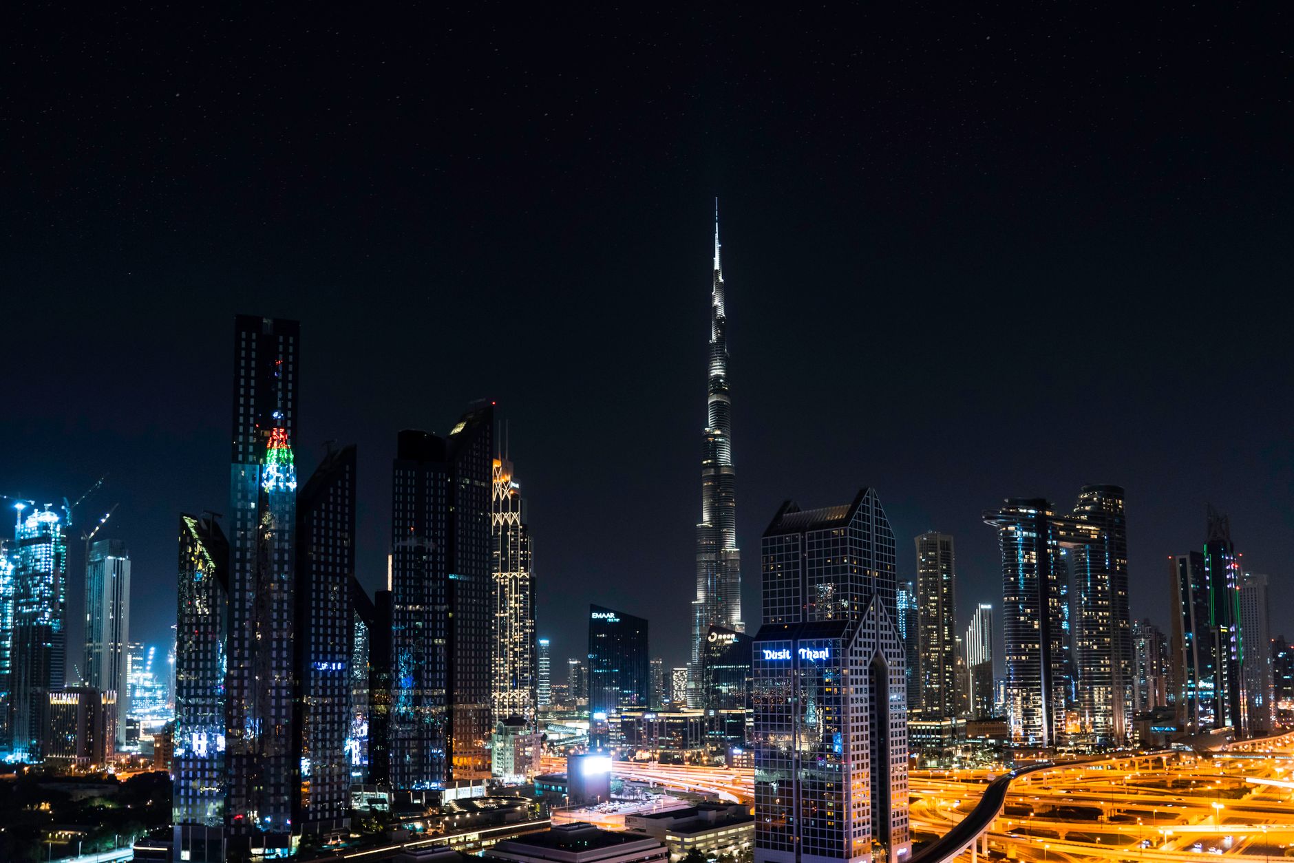 Mrakodrap Burj Khalifa tyčící se nad centrem Dubaje s okolními výškovými budovami