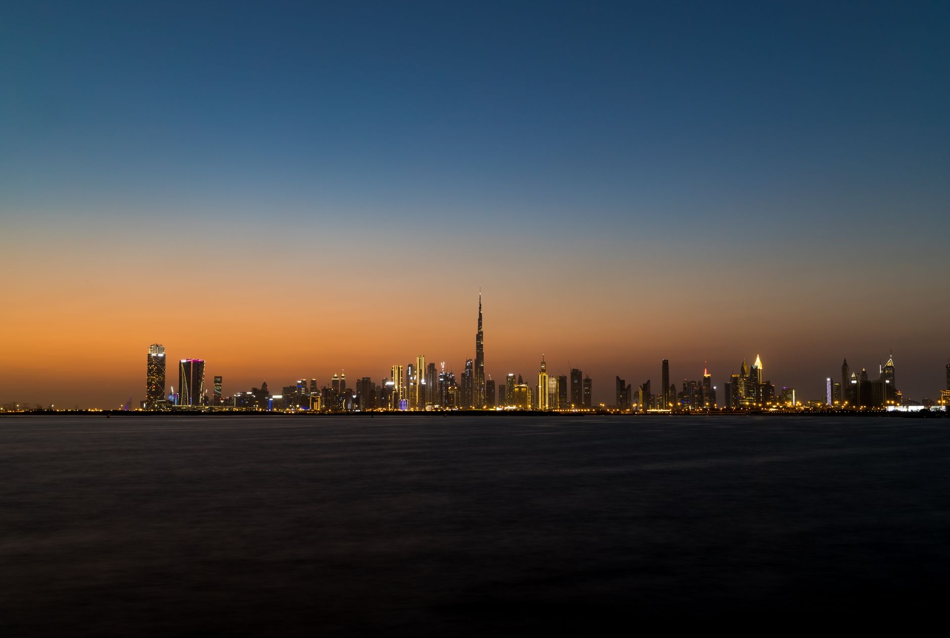 Panorama Dubaje s mrakodrapem Burj Khalifa a moderní zástavbou při západu slunce