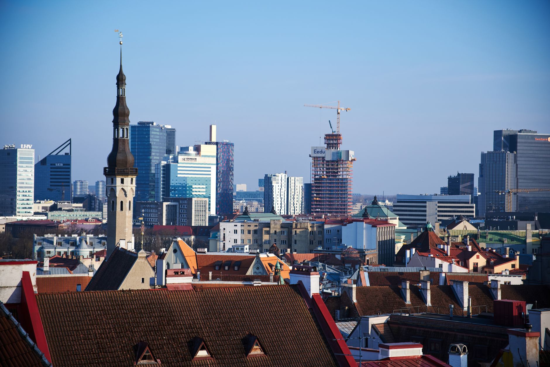 Panorama starého města Tallinnu s červenými střechami, věžemi a hradbami nad Finským zálivem