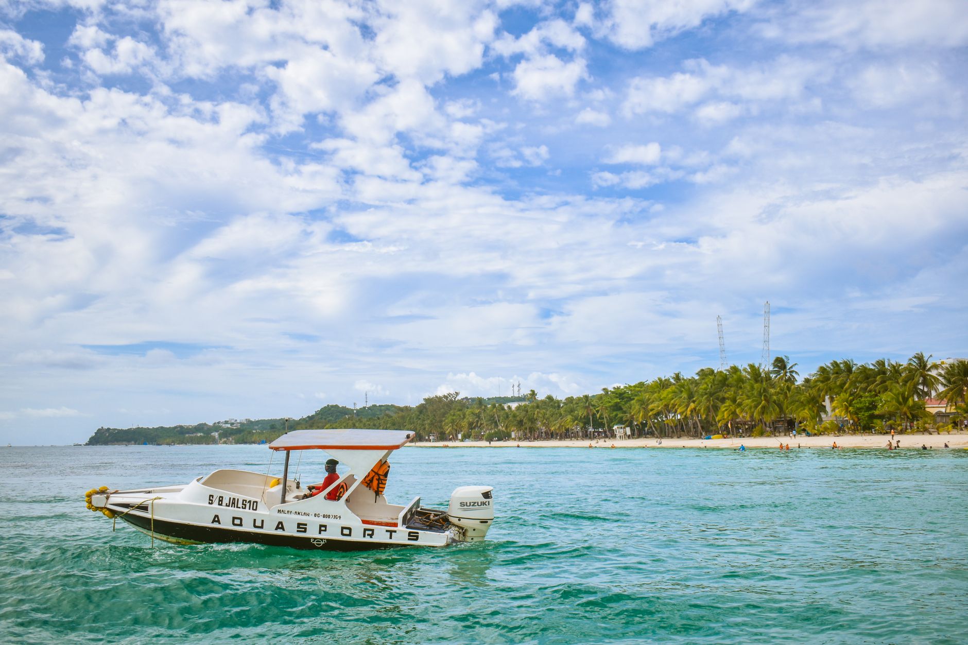 Pudrově bílá pláž White Beach s tyrkysovým mořem a palmami na ostrově Boracay