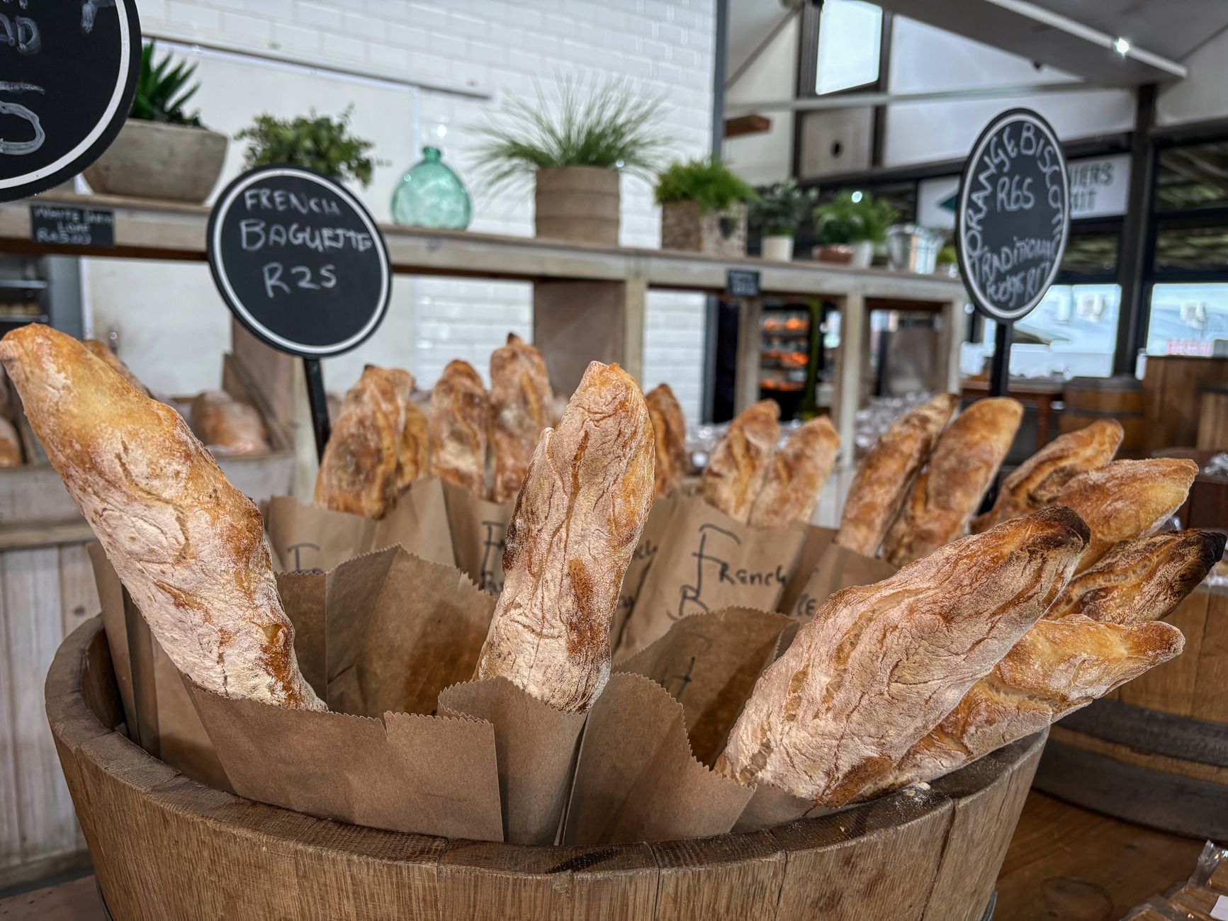 Tradiční francouzské bagety a croissanty vyrovnané v koši ve výloze pekárny
