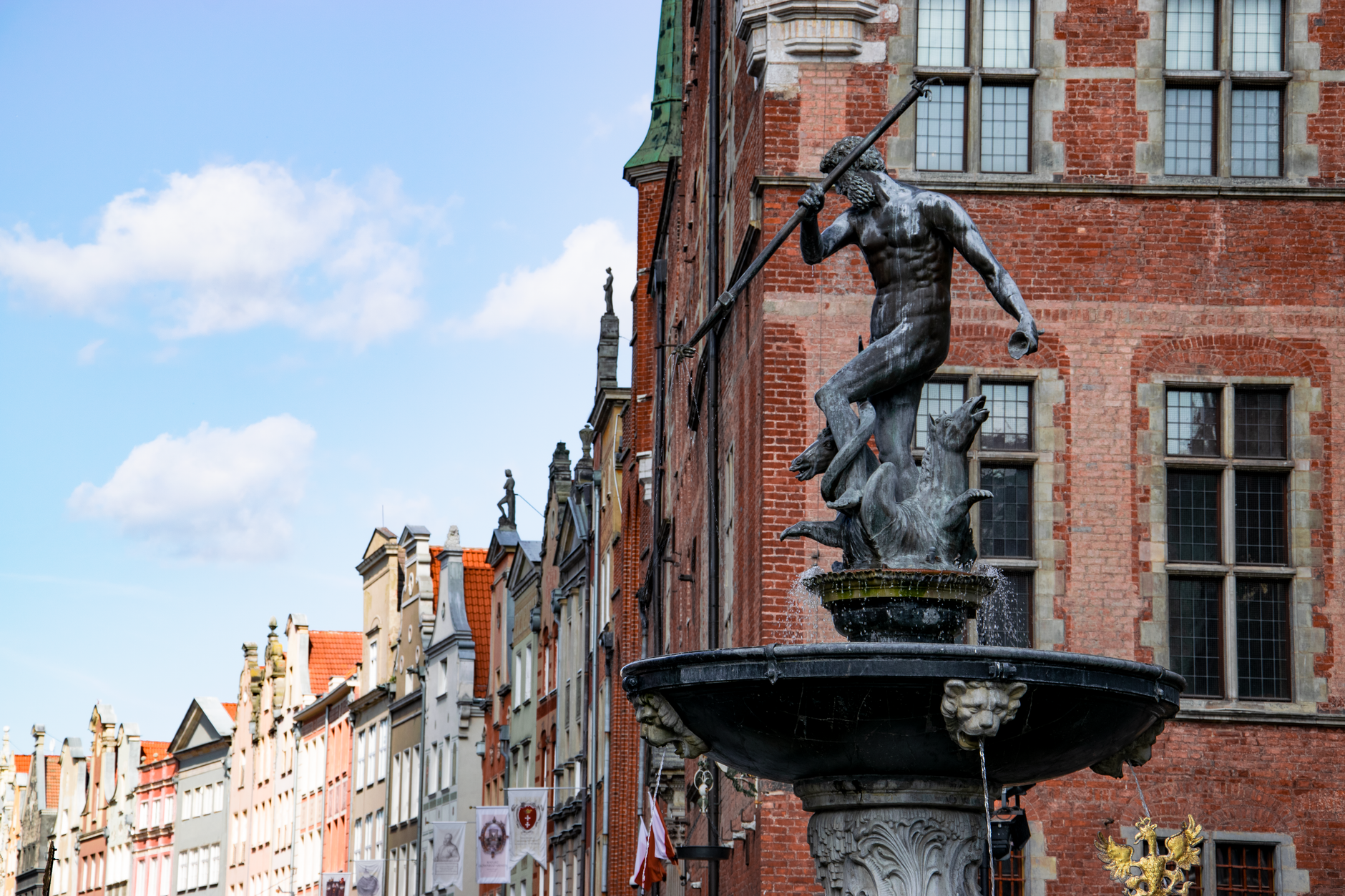 Pohled na hlavní třídu Długi Targ v Gdaňsku s historickými měšťanskými domy a fontánou Neptuna