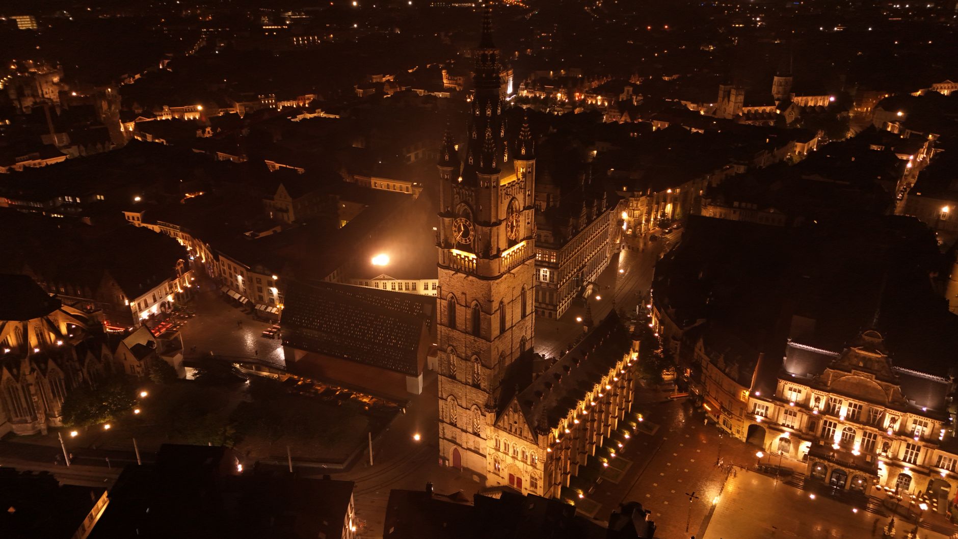 Osvětlené historické cechovní domy na nábřeží Graslei nad kanálem v Gentu večer