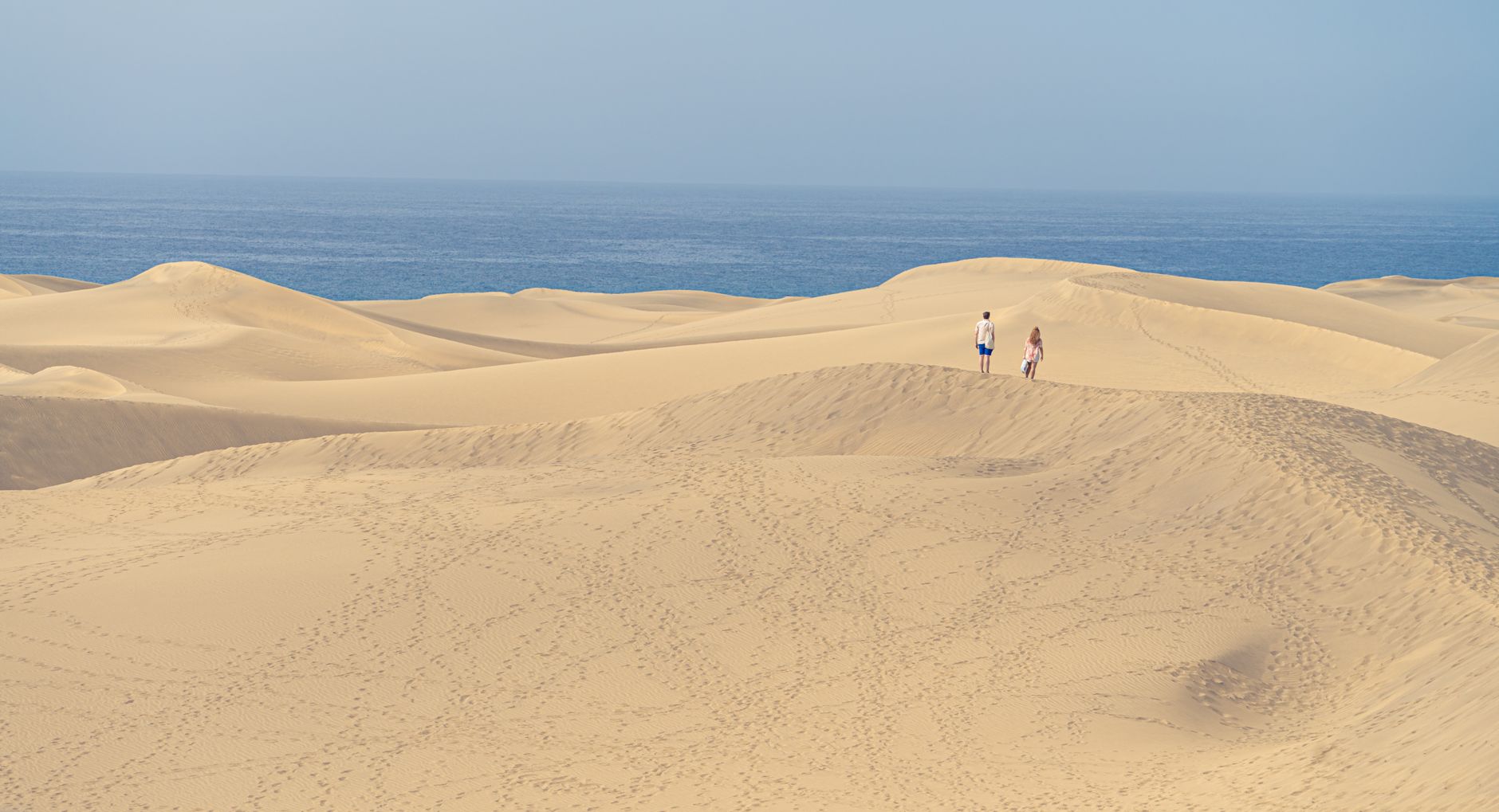 Pohled na duny Maspalomas na Gran Canarii s pískem a Atlantikem v pozadí