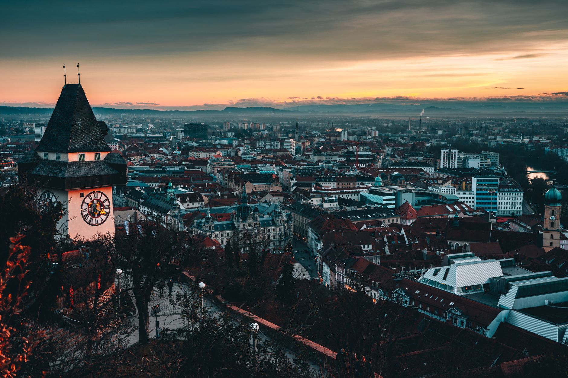 Panorama Grazu s hradním vrchem Schlossberg, věží Uhrturm a červenými střechami starého města