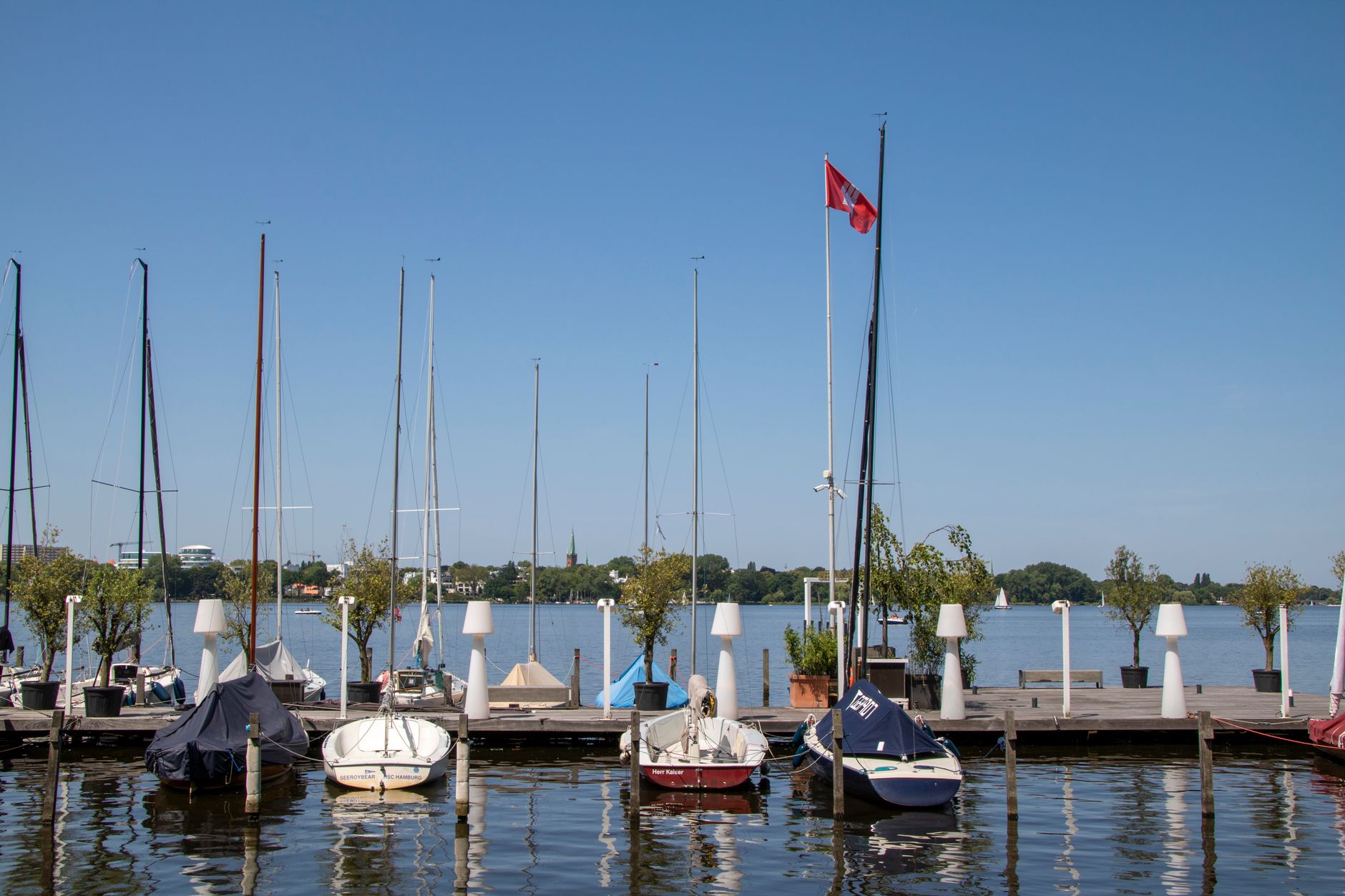 Plachetnice na jezeře Außenalster v centru Hamburku s panoramatem města v pozadí