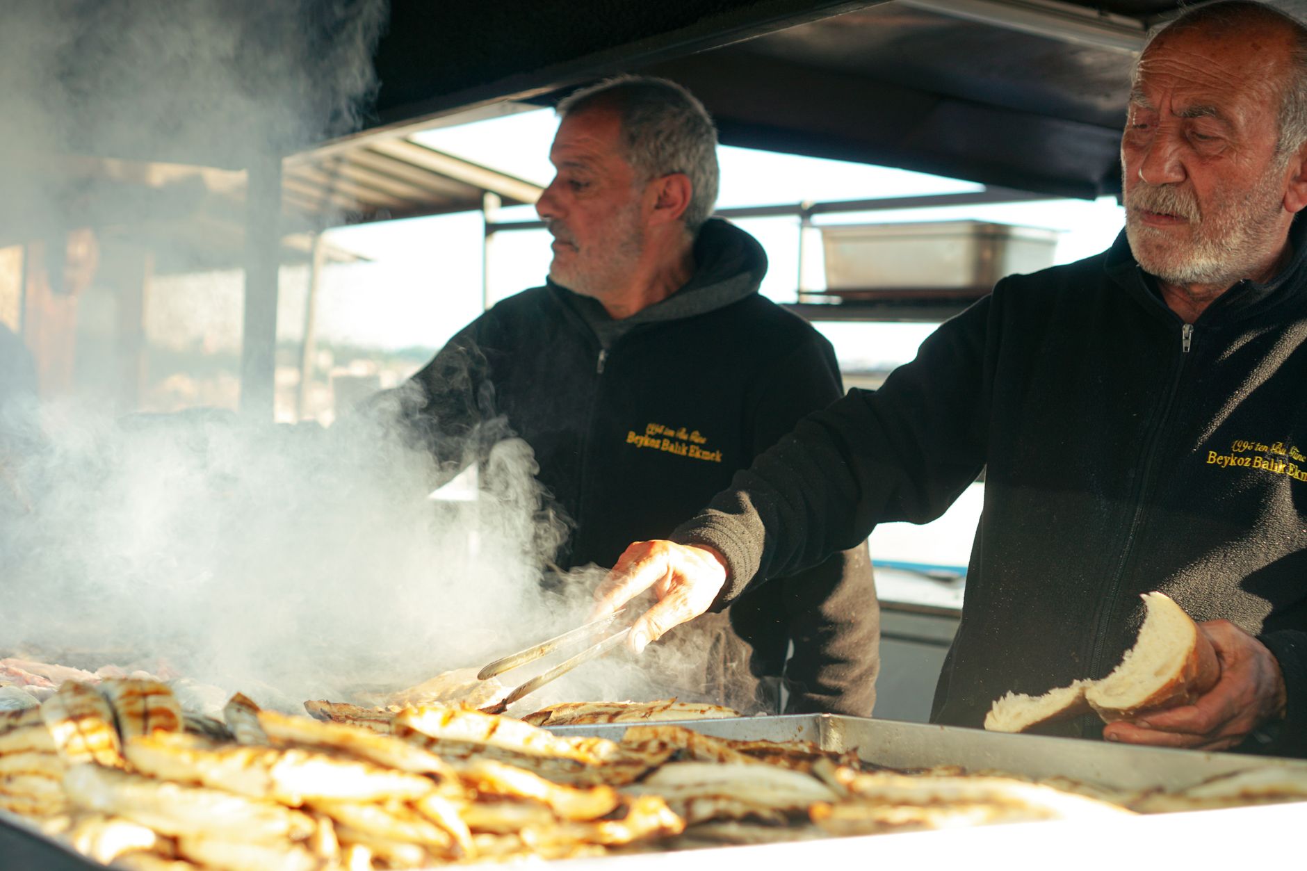 Stánek s rybí houskou Fischbrötchen s nakládaným sledem a cibulí u hamburského přístavu