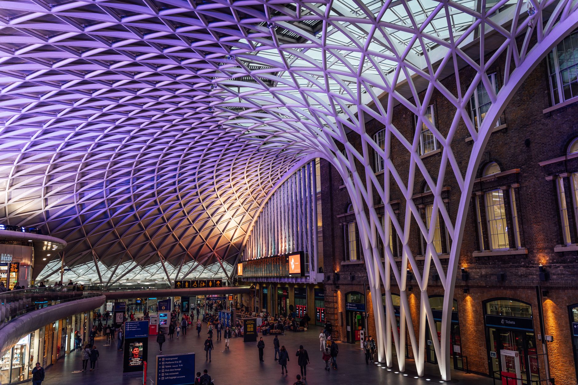 Historické nádraží King's Cross v Londýně s prosklenou klenutou střechou nad nástupišti