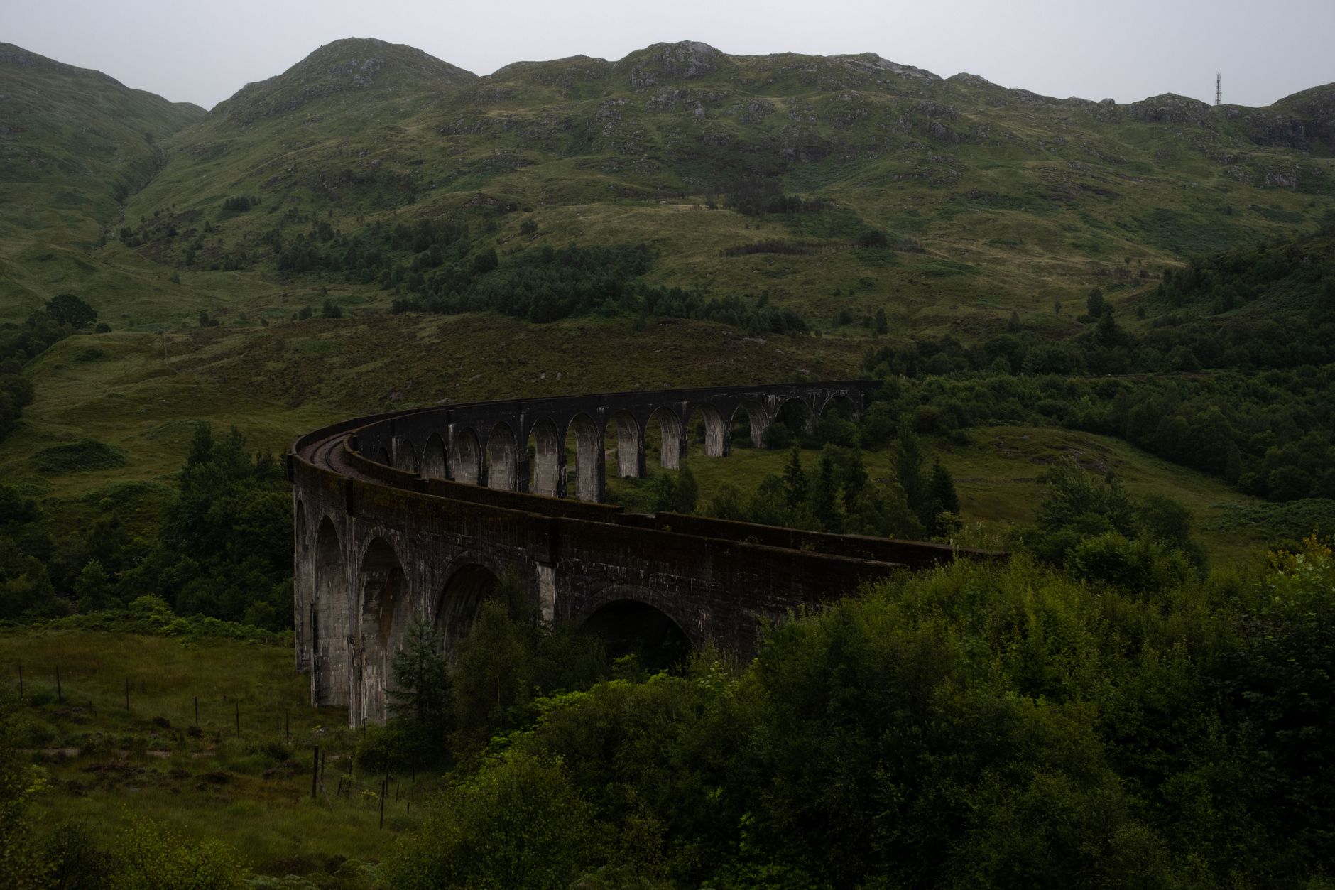 Viadukt Glenfinnan v zeleném údolí, po kterém ve filmech o Harrym Potterovi jezdí Bradavický expres