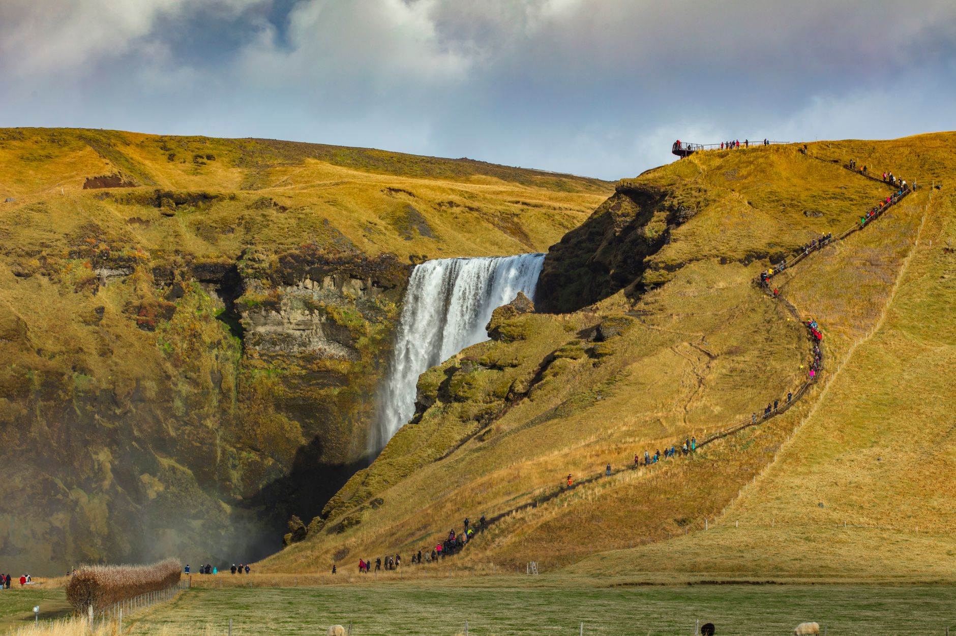 Vodopád Skógafoss na jižním Islandu padající přes čedičovou stěnu do zelené krajiny
