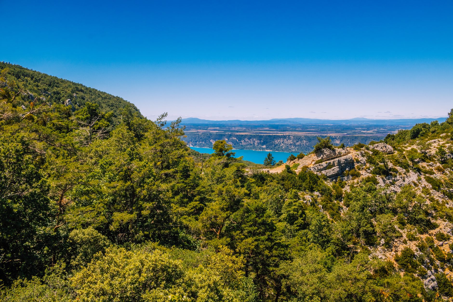 Tyrkysová řeka na dně soutěsky Gorges du Verdon s vysokými skalními stěnami v jižní Francii