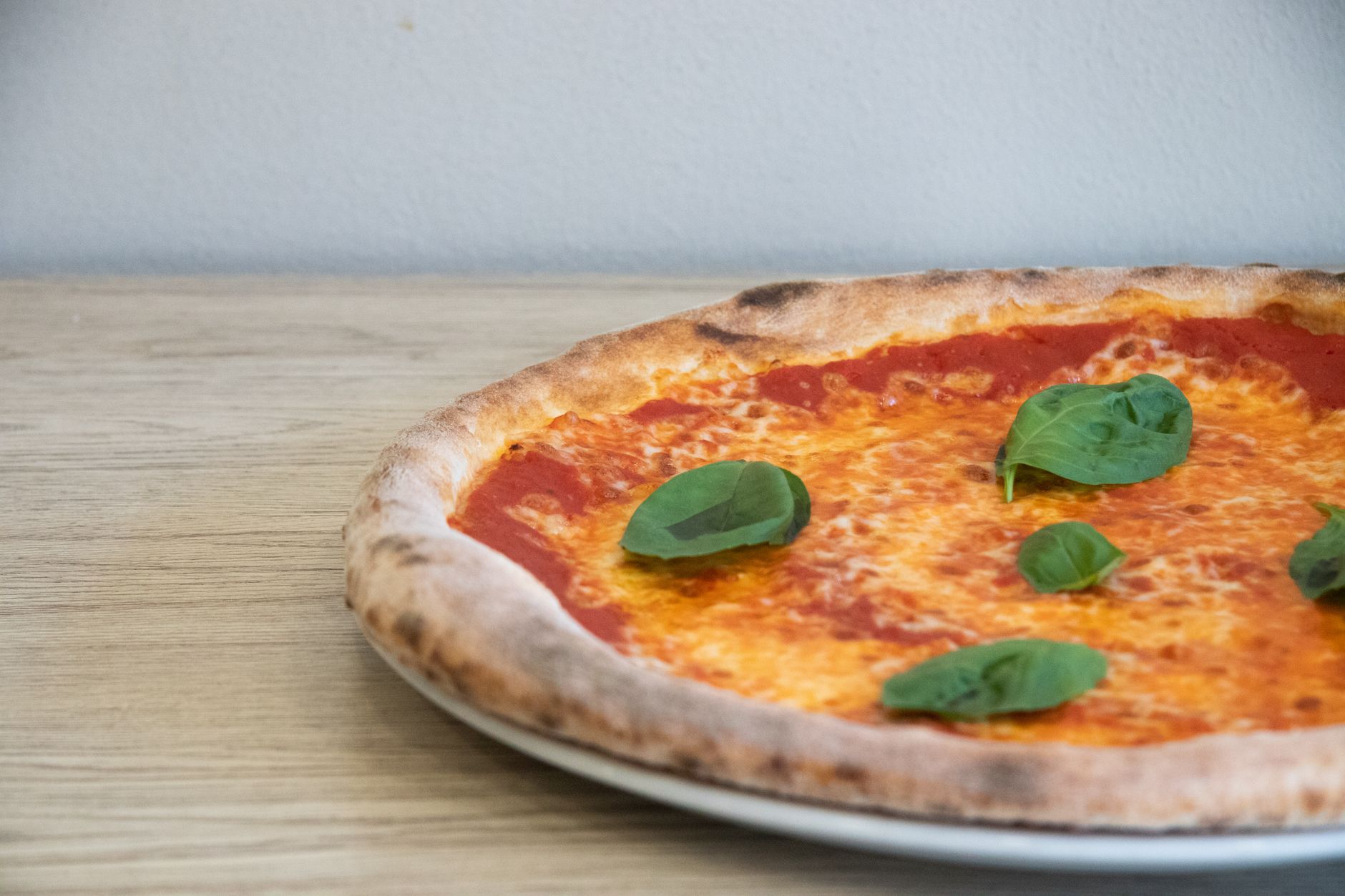 Pravá neapolská pizza margherita s nadýchaným okrajem na dřevěném stole