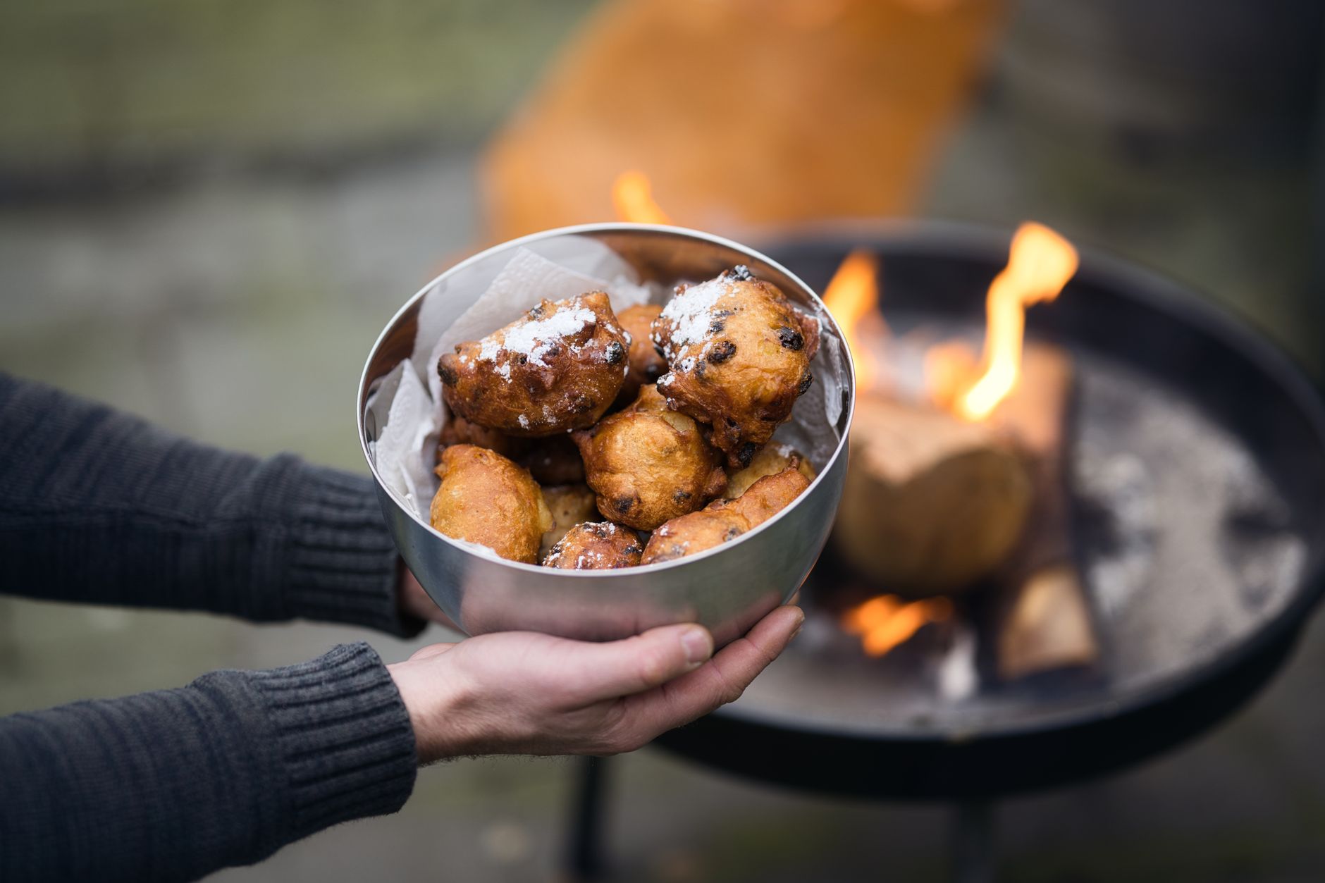 Smažené karnevalové frittelle posypané cukrem na talíři