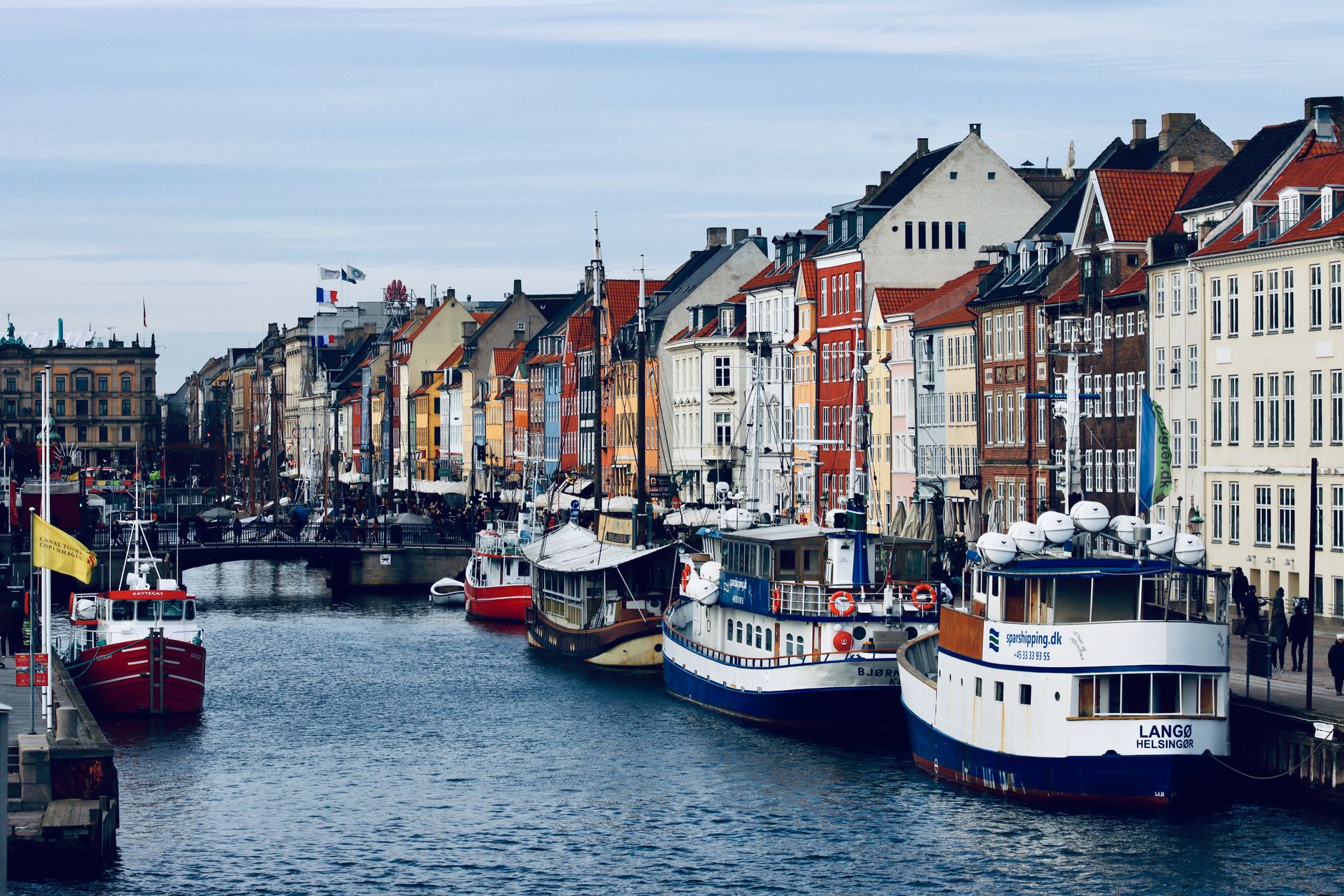 Barevné domy a dřevěné lodě v přístavu Nyhavn v Kodani za slunečného dne