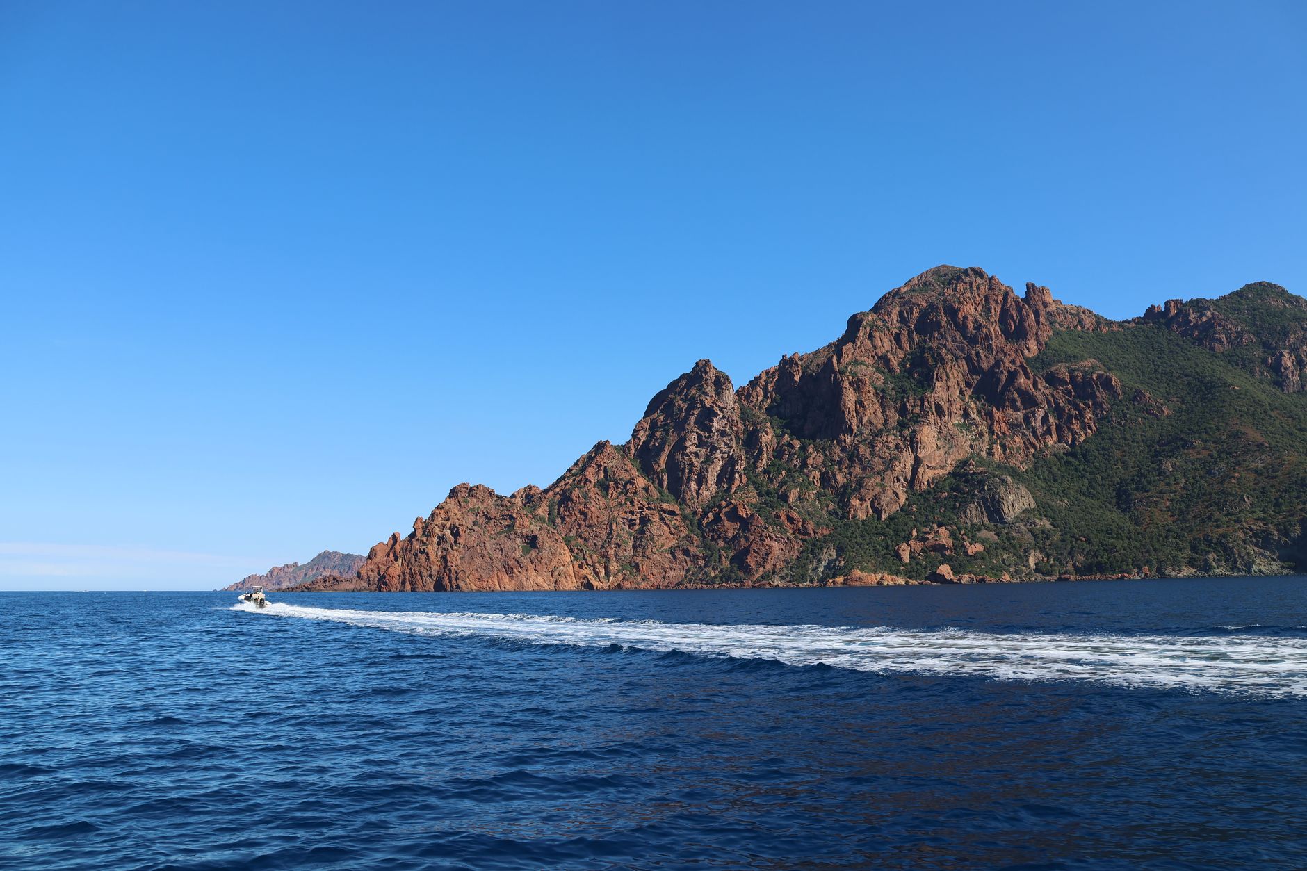 Pobřeží Korsiky s červenými skalami Calanques de Piana spadajícími do tyrkysového moře