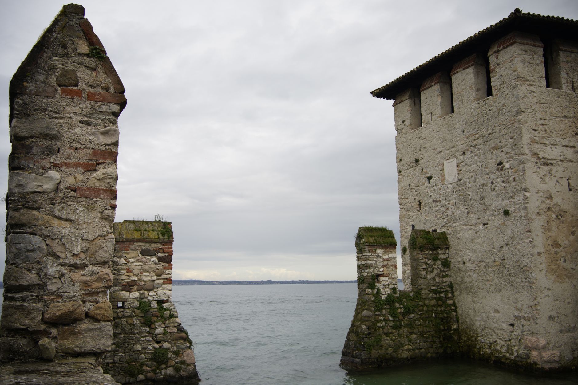 Středověký vodní hrad Scaligerů ve městečku Sirmione obklopený hladinou jezera Garda